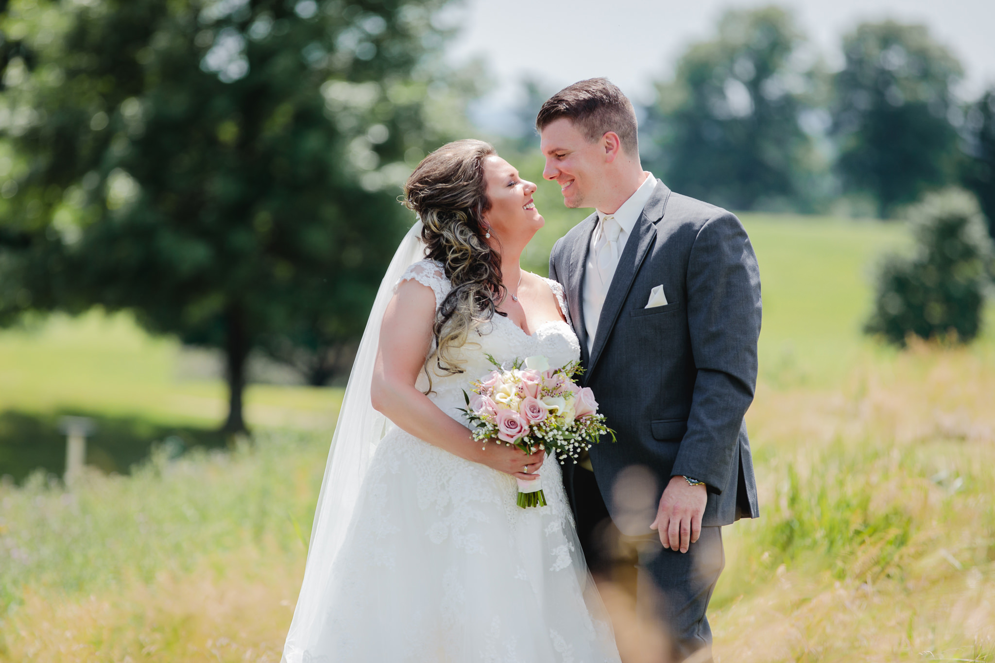 Bride and groom smile at each other during portraits at Chestnut Ridge Golf Resort