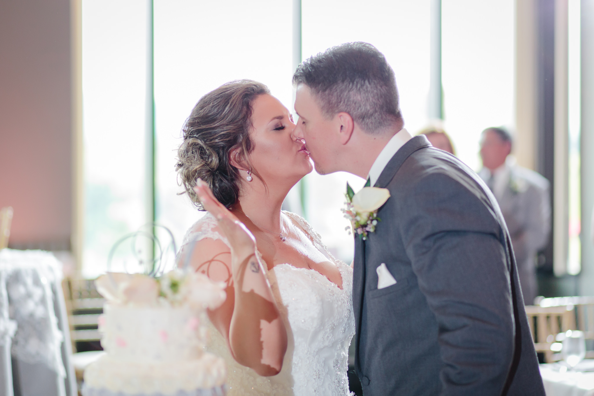 Newlyweds kiss after cake cutting at Chestnut Ridge Golf Resort