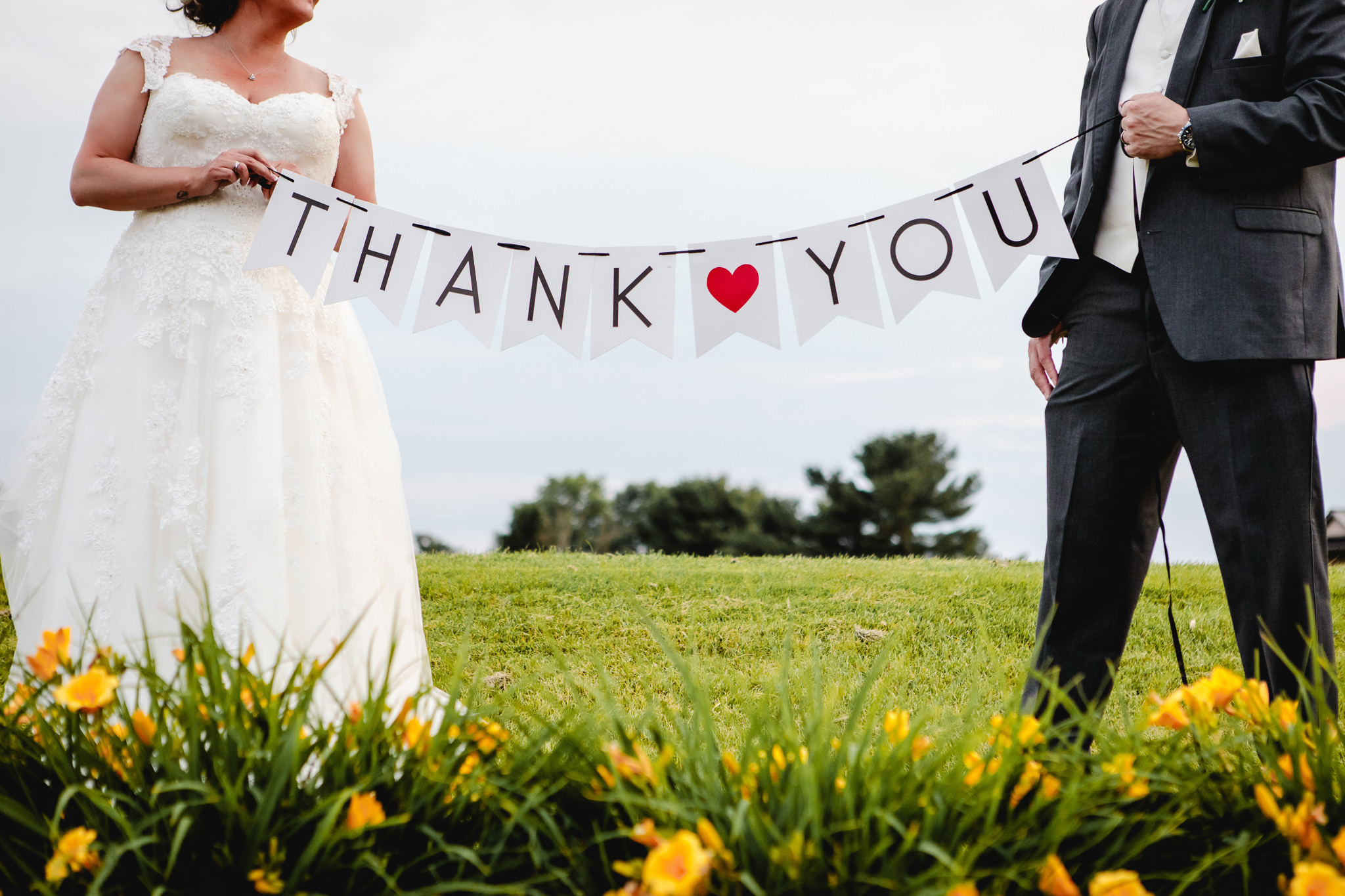 Bride and groom hold up a thank you sign at Chestnut Ridge Golf Resort