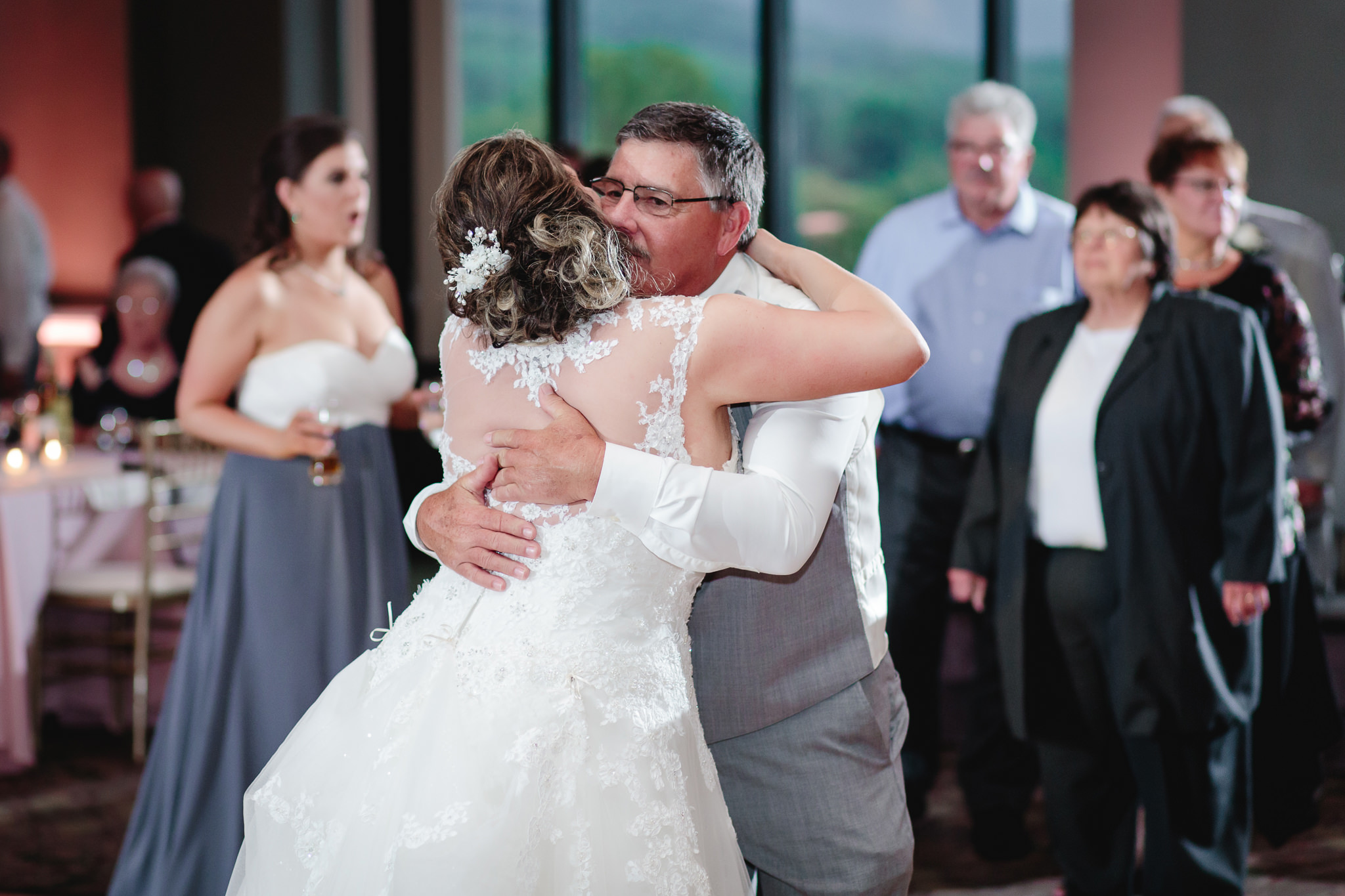 Father of the groom hugs the bride at Chestnut Ridge Golf Resort