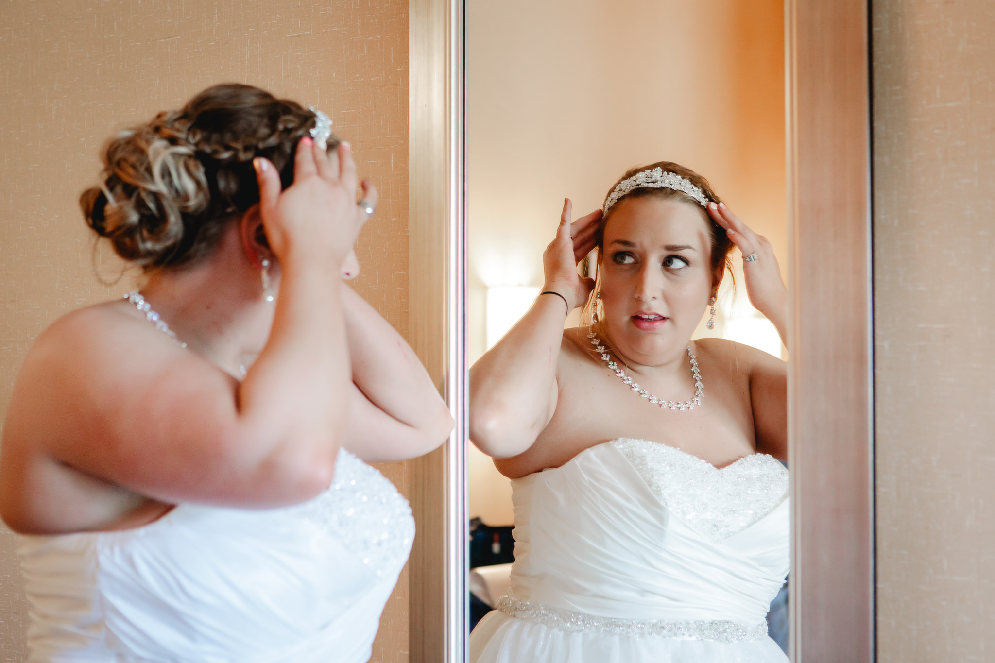 Bride adjusts her tiara in the mirror before her Duquesne University wedding
