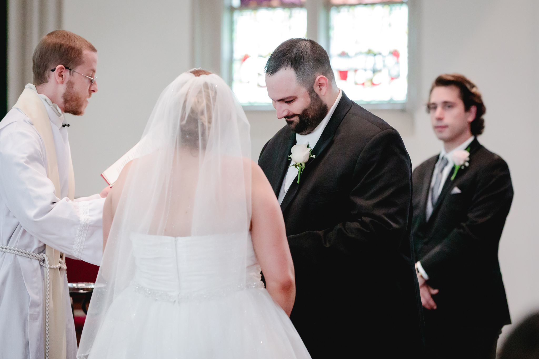 Groom puts a ring on his bride's finger at their Duquesne University wedding ceremony