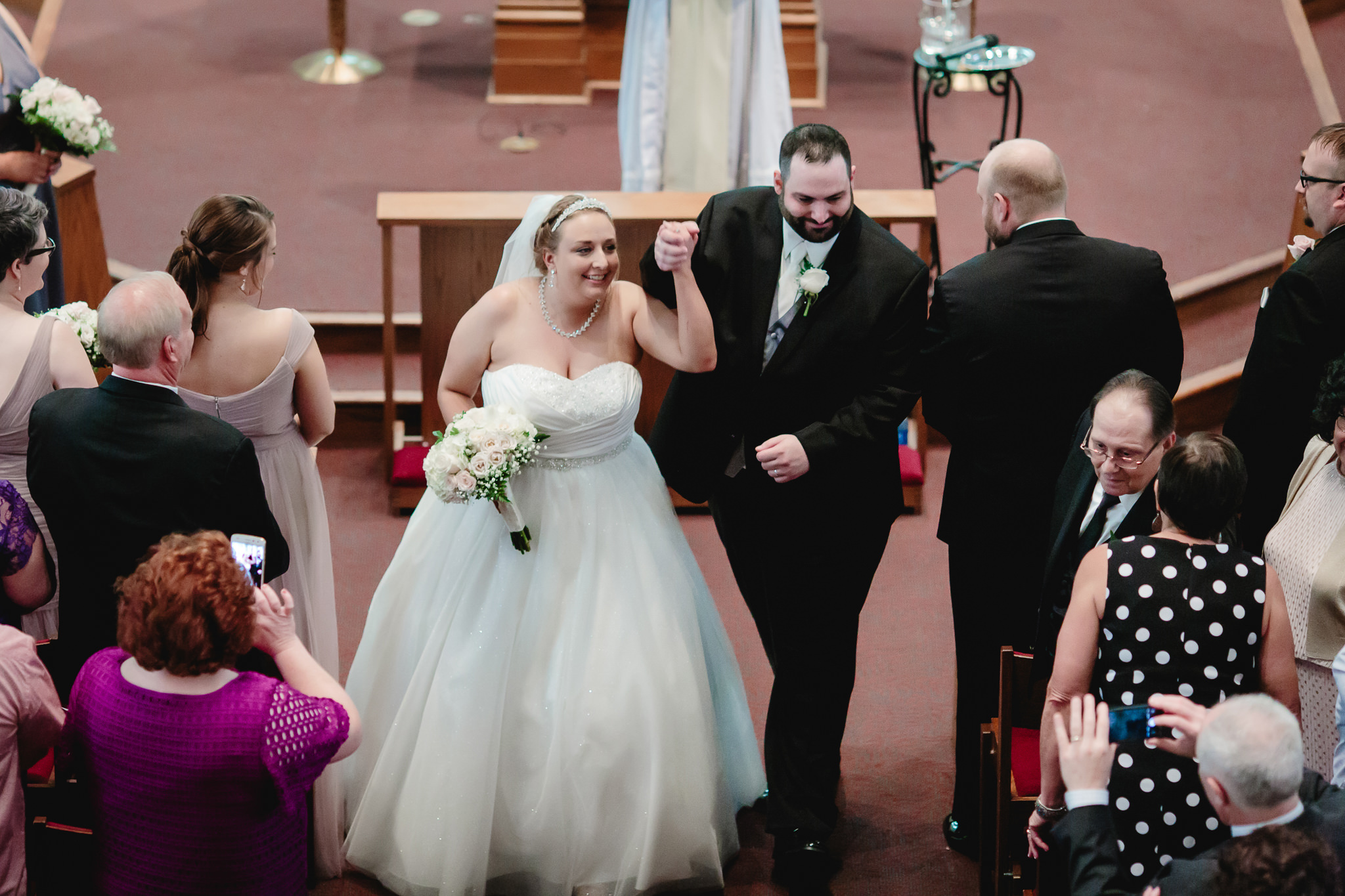 Bride and groom cheer as they exit their Duquesne University wedding ceremony
