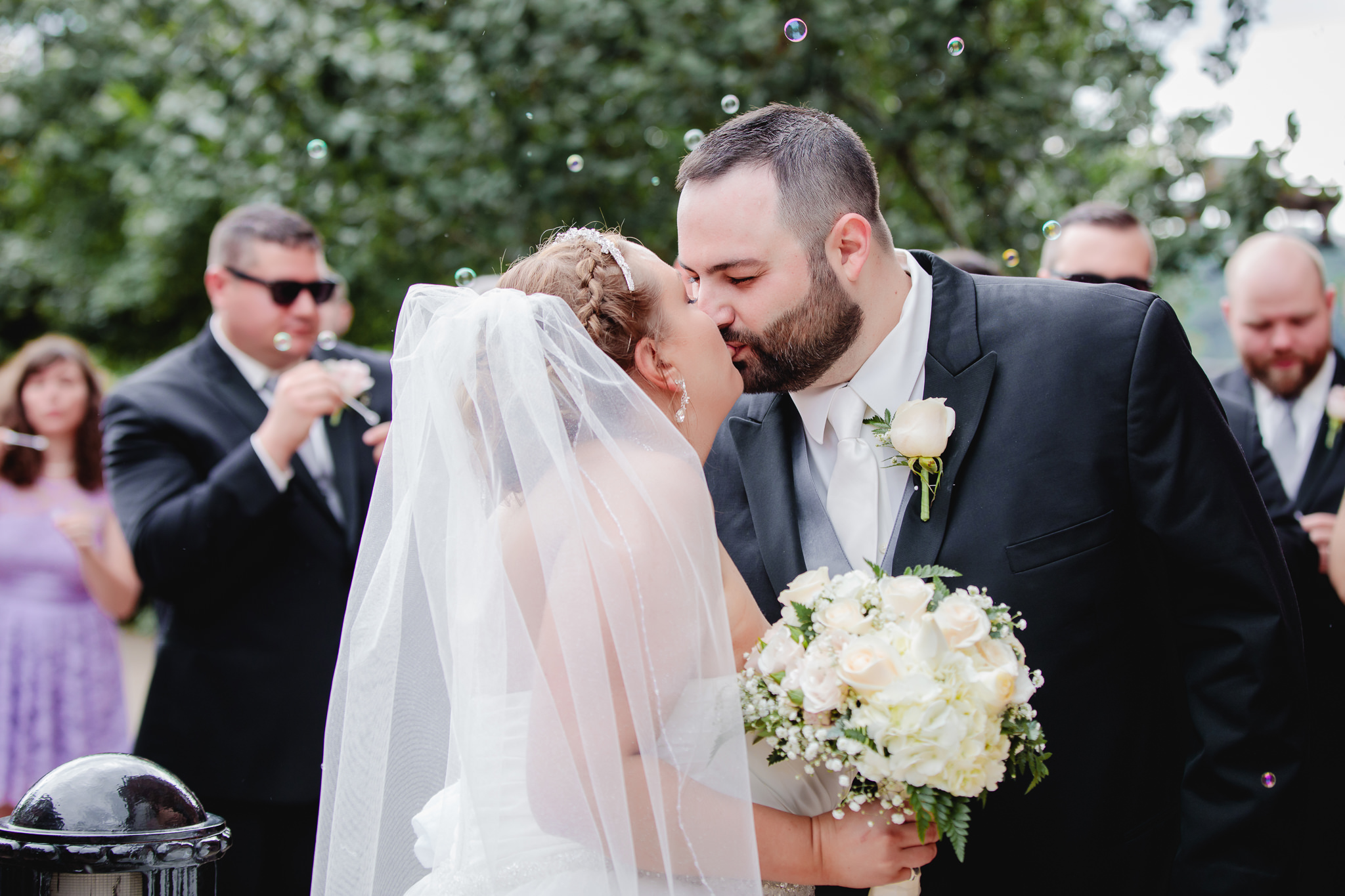Newlyweds kiss during the bubble exit at Duquesne University
