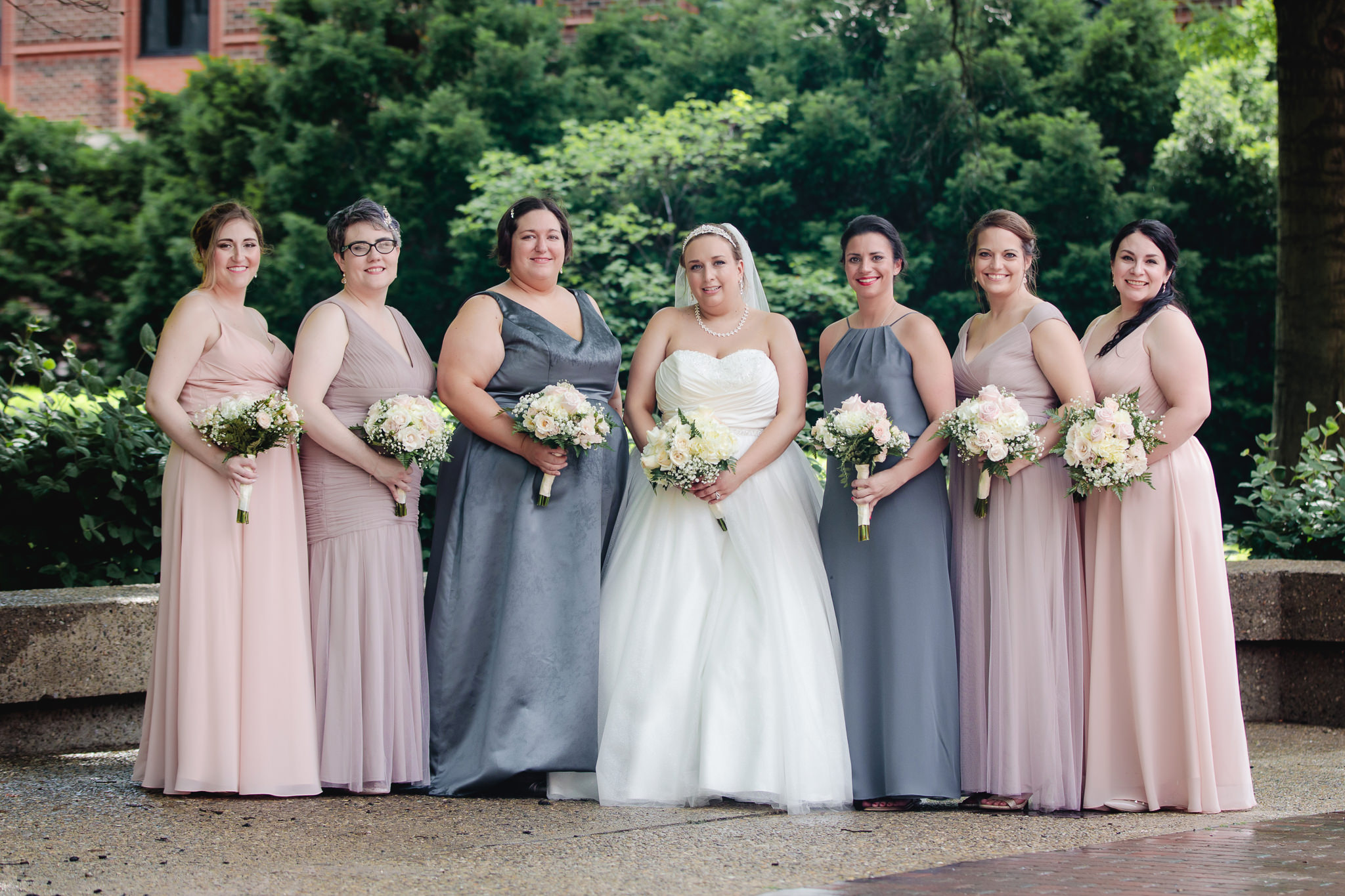 Bridesmaids wear different shades of neutral palette dresses