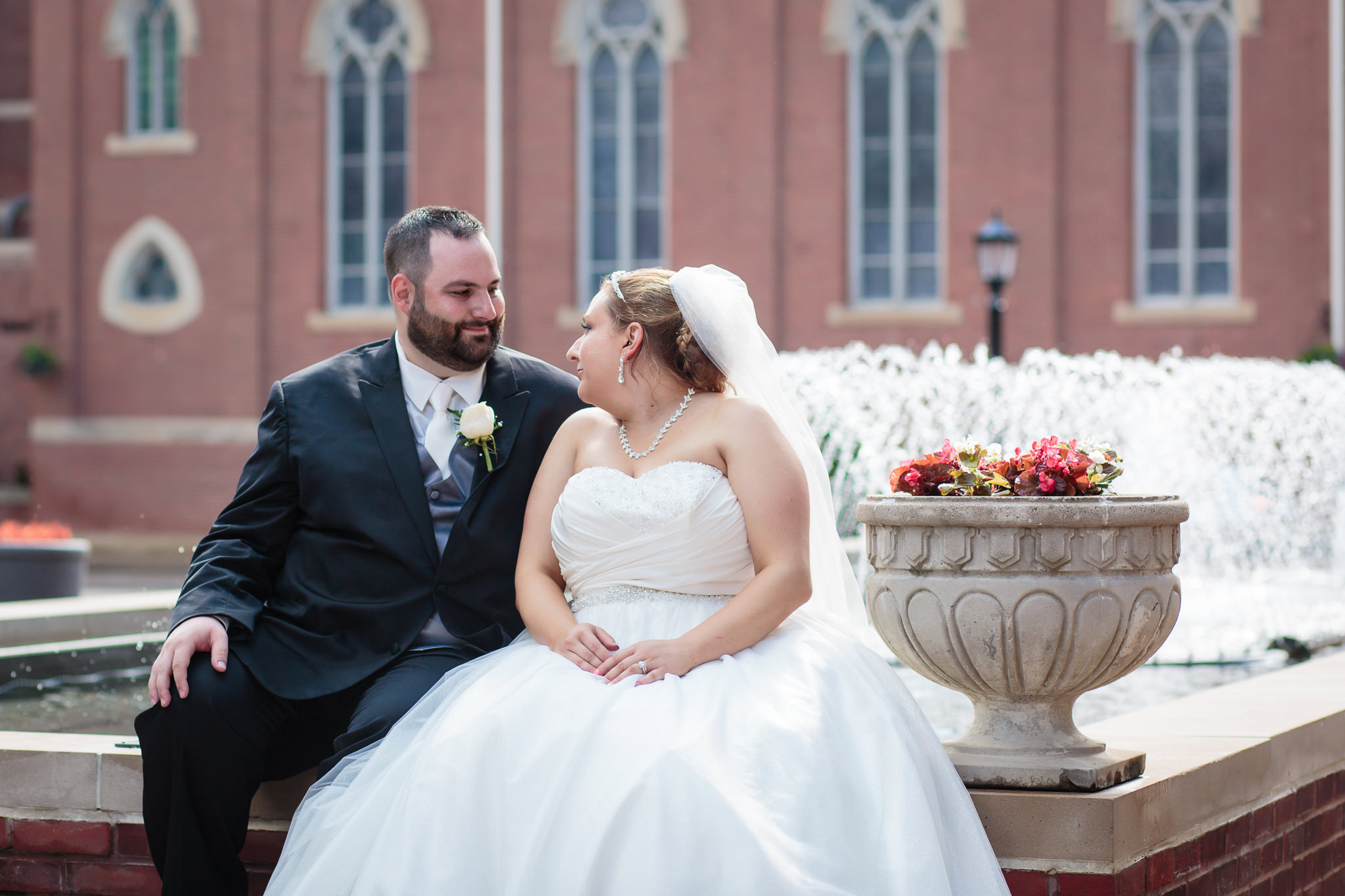 Bride & groom sit by the fountain at Duquesne University