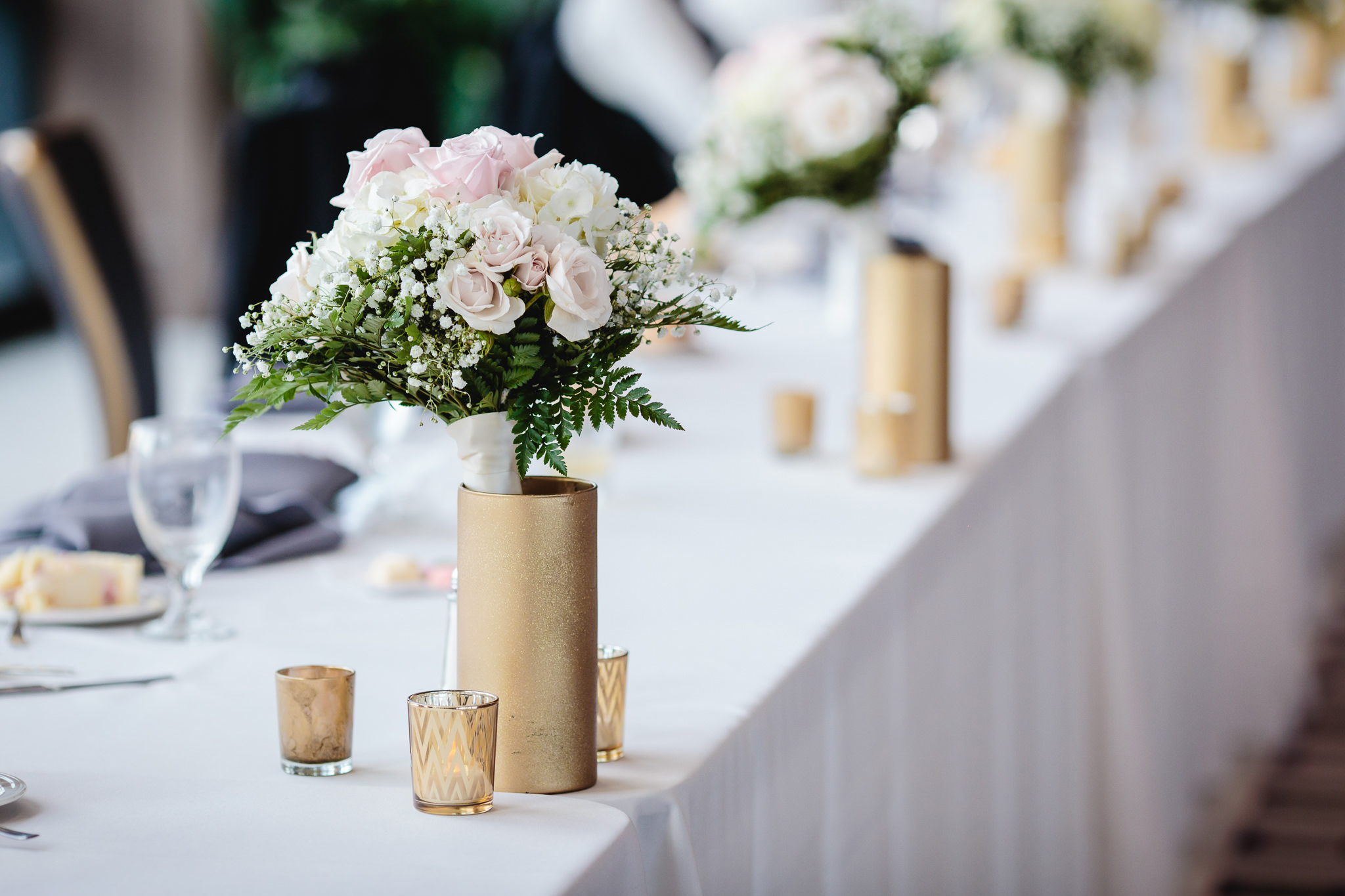 Bridesmaids' bouquets decorate the head table at Duquesne University
