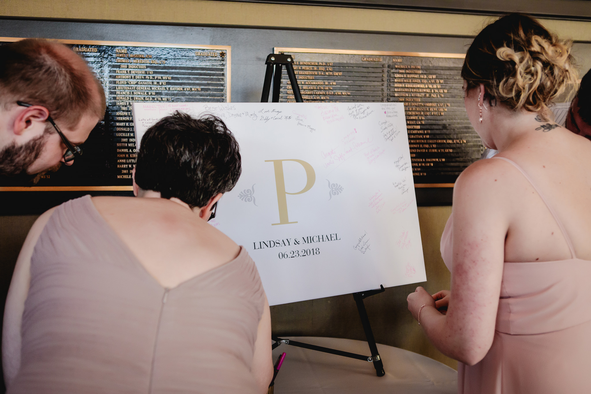 Bridesmaids sign the guestbook canvas at Duquesne University