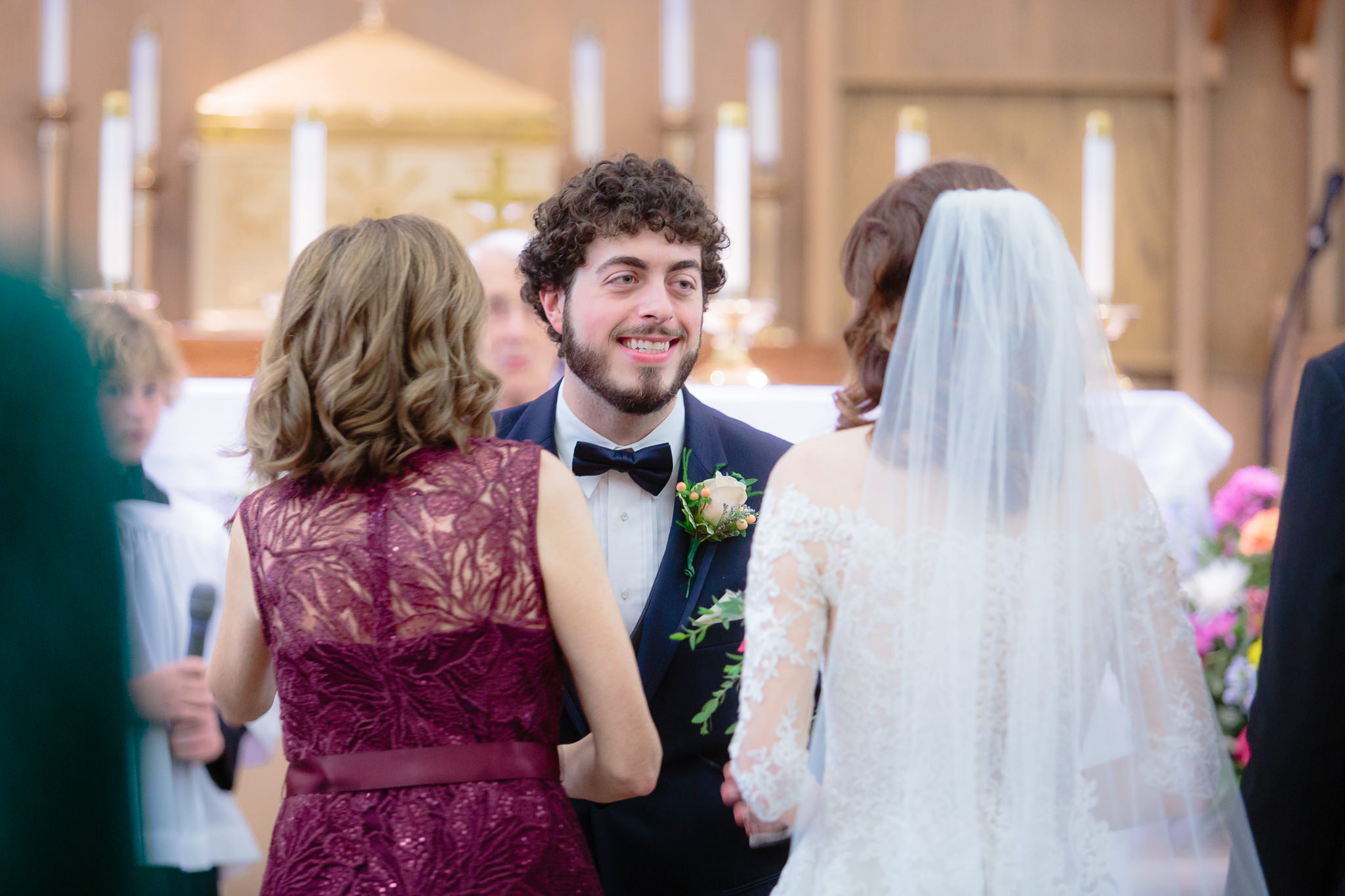 Groom smiles as his bride is presented to him at Saint Monica Parish