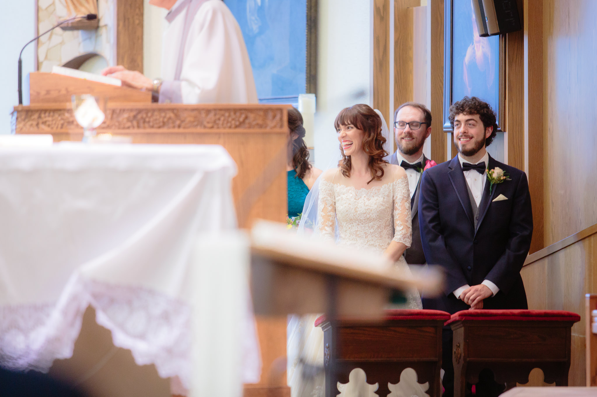Bride & groom laugh during their wedding ceremony at Saint Monica Parish