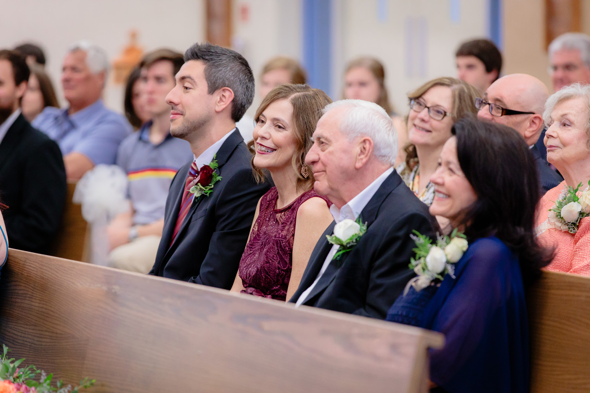 Bride's family smiles during the homily at a Saint Monica Parish wedding ceremony