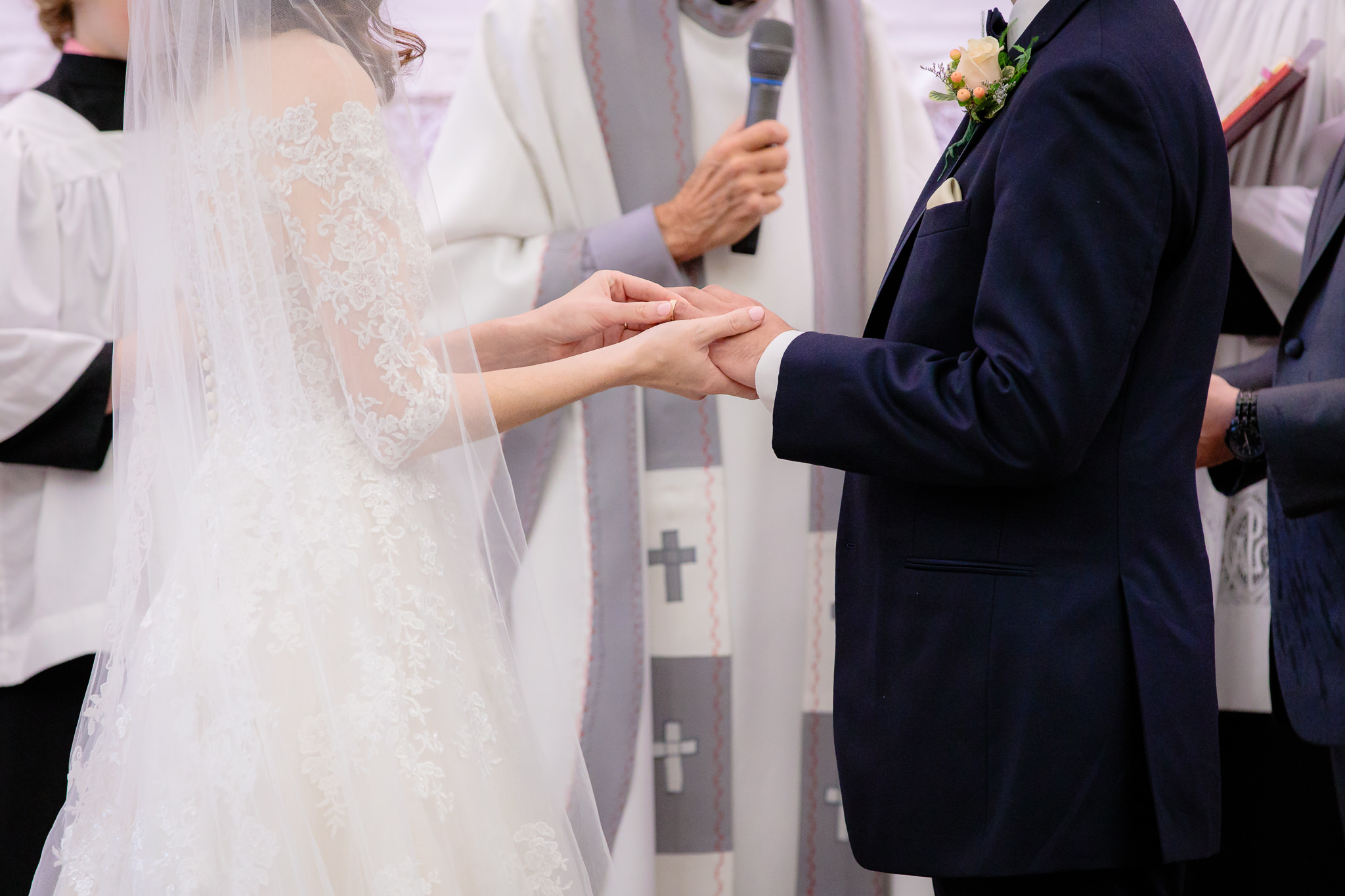 Bride puts groom's ring on his finger at Saint Monica Parish