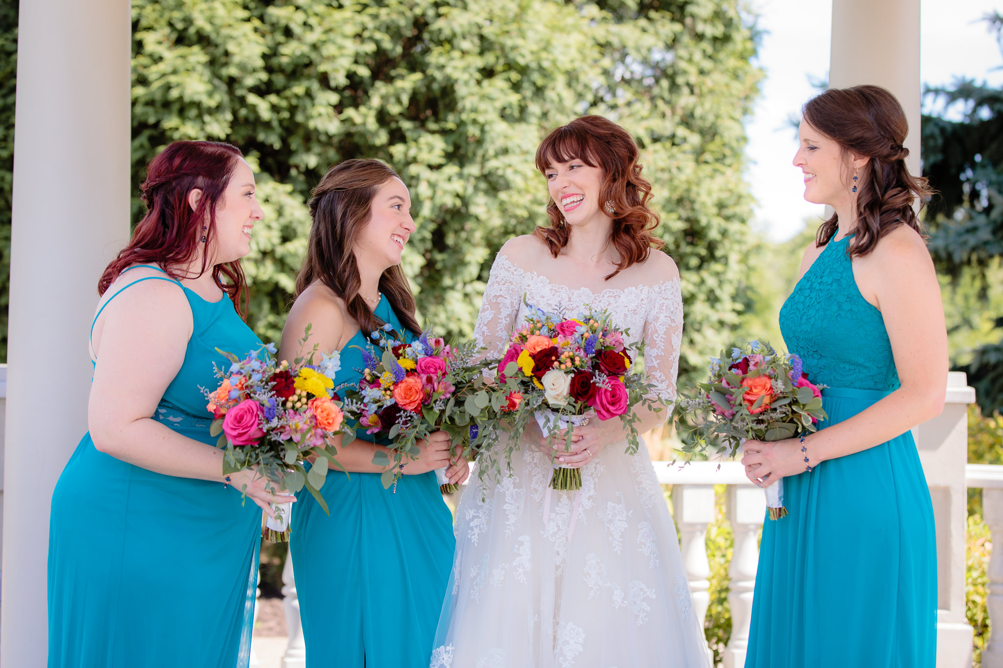 Bridesmaids laugh with bride in the gazebo at Beaver Station