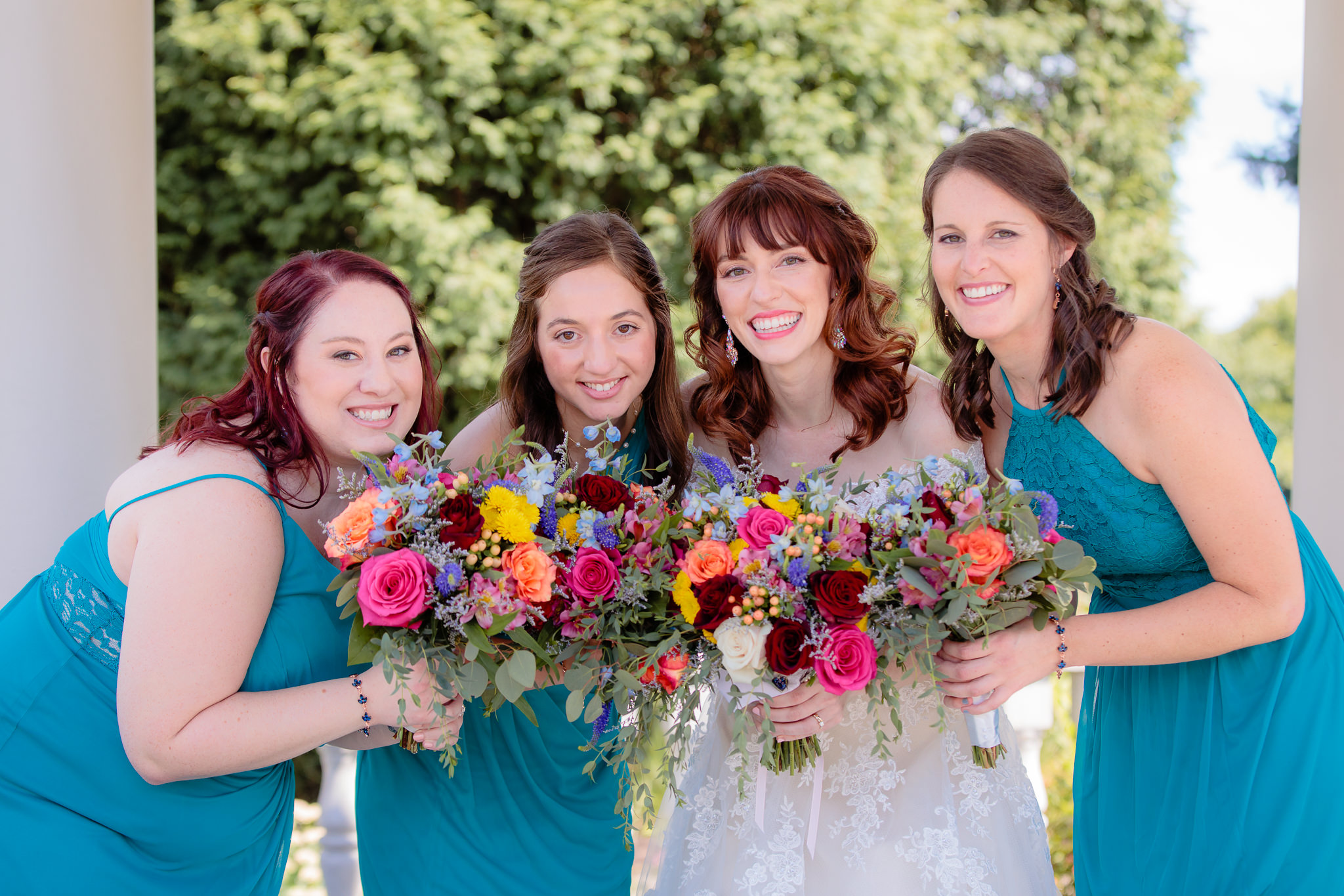 Bridesmaids hold colorful bouquets by Patti's Petals Flower Shop at Beaver Station