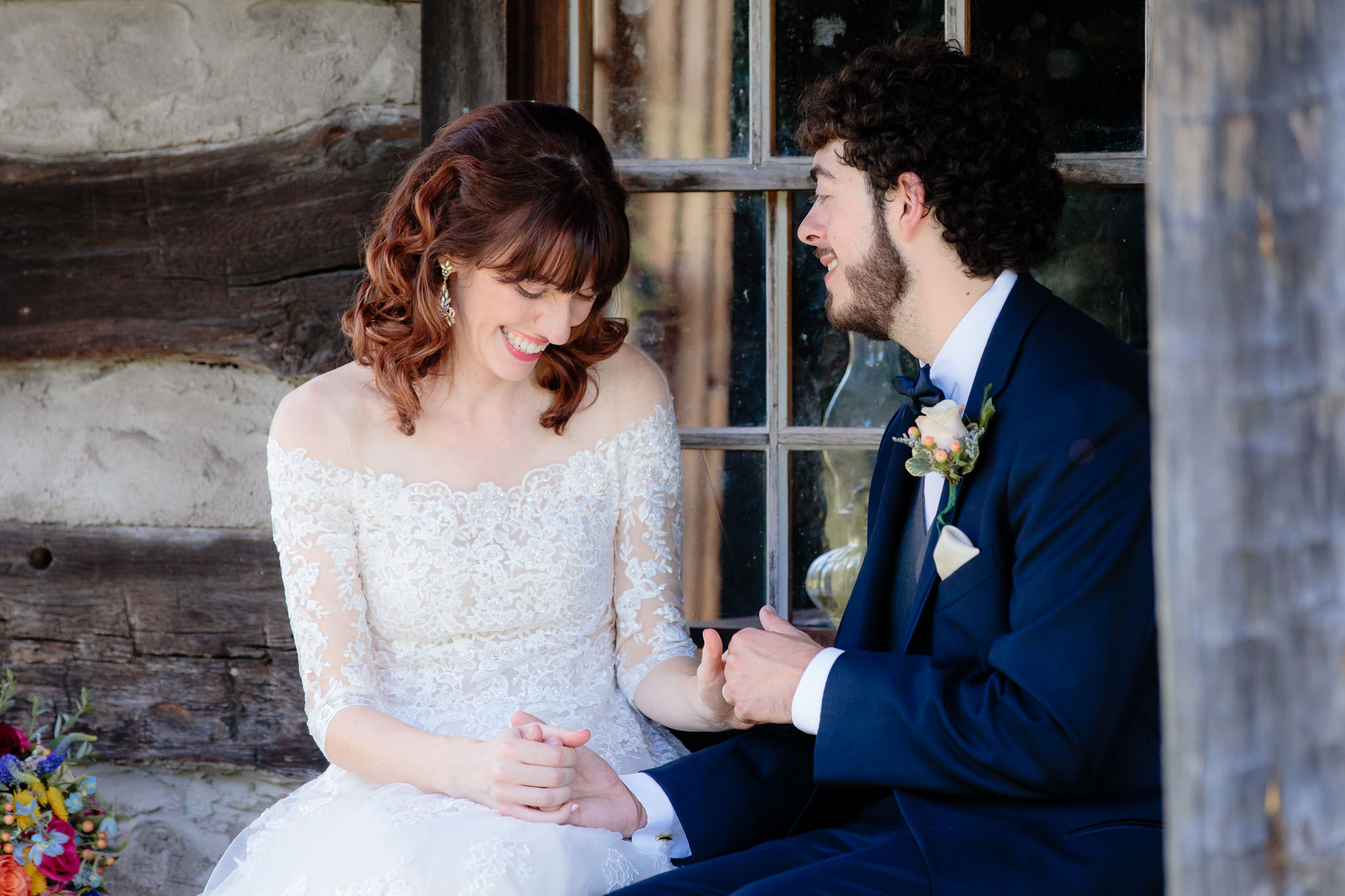 Bride smiles with her groom at the log cabin at Beaver Station