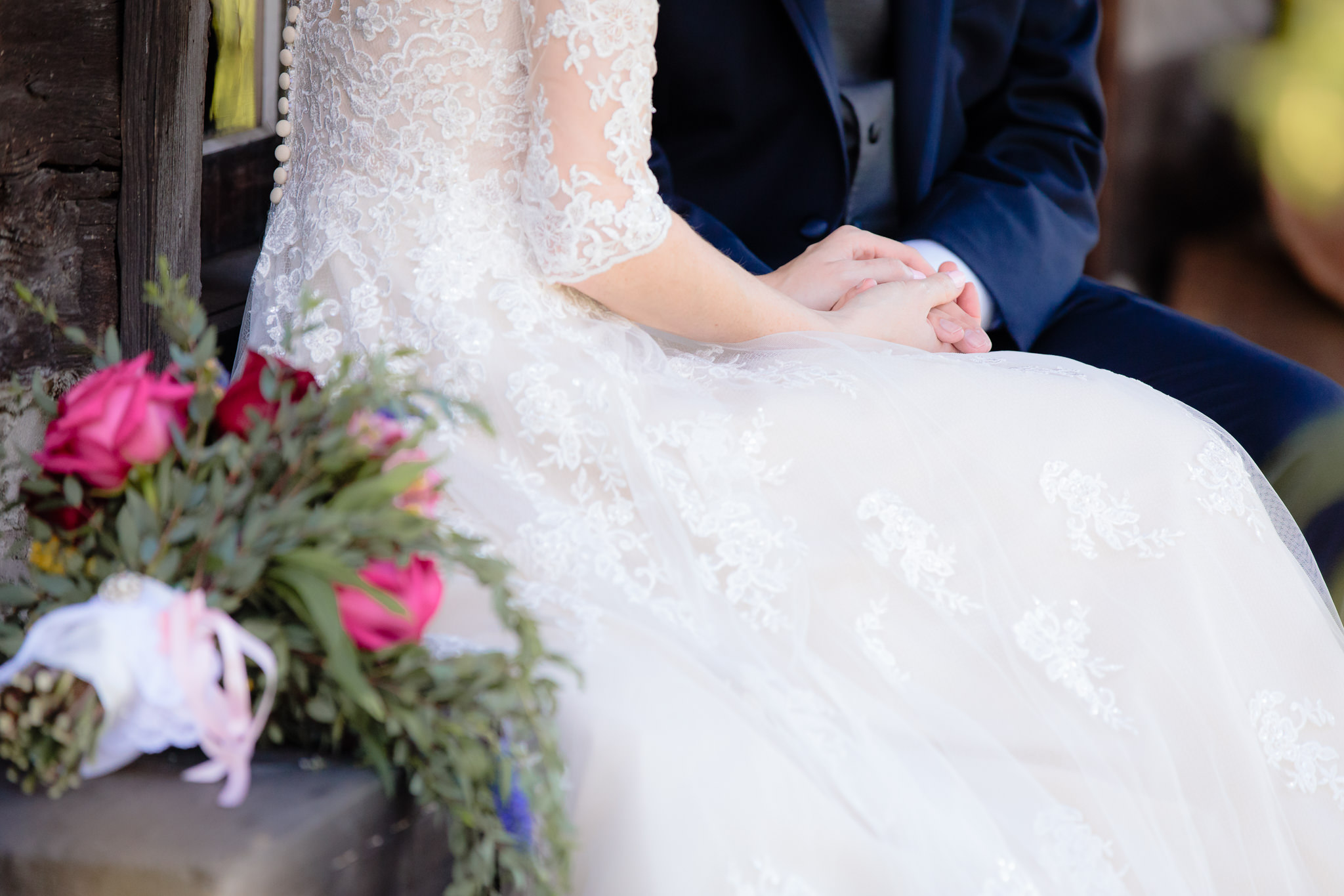 Bride & groom hold hands on a log cabin porch at Beaver Station