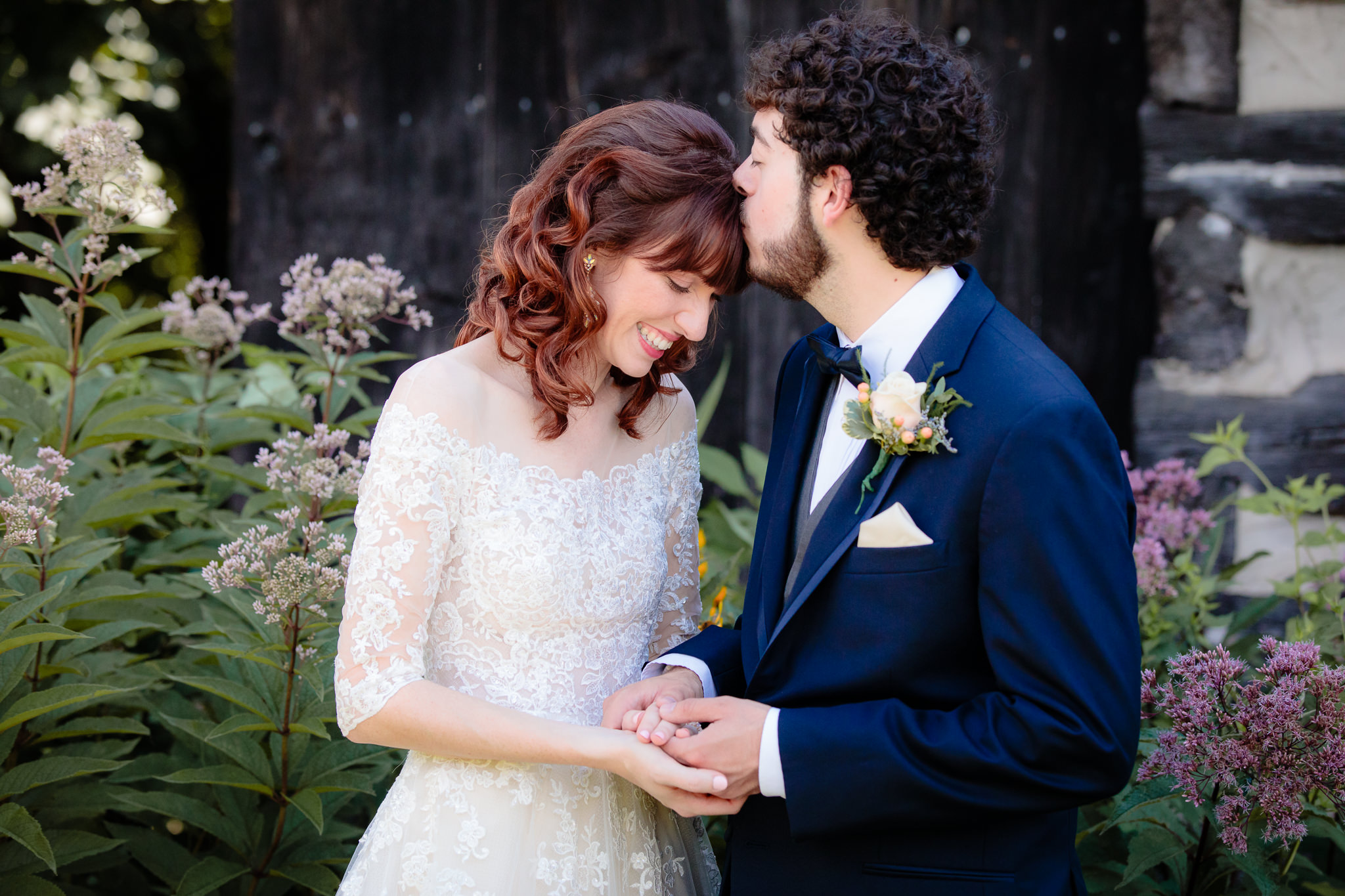 Groom kisses the bride's forehead during portraits at Beaver Station