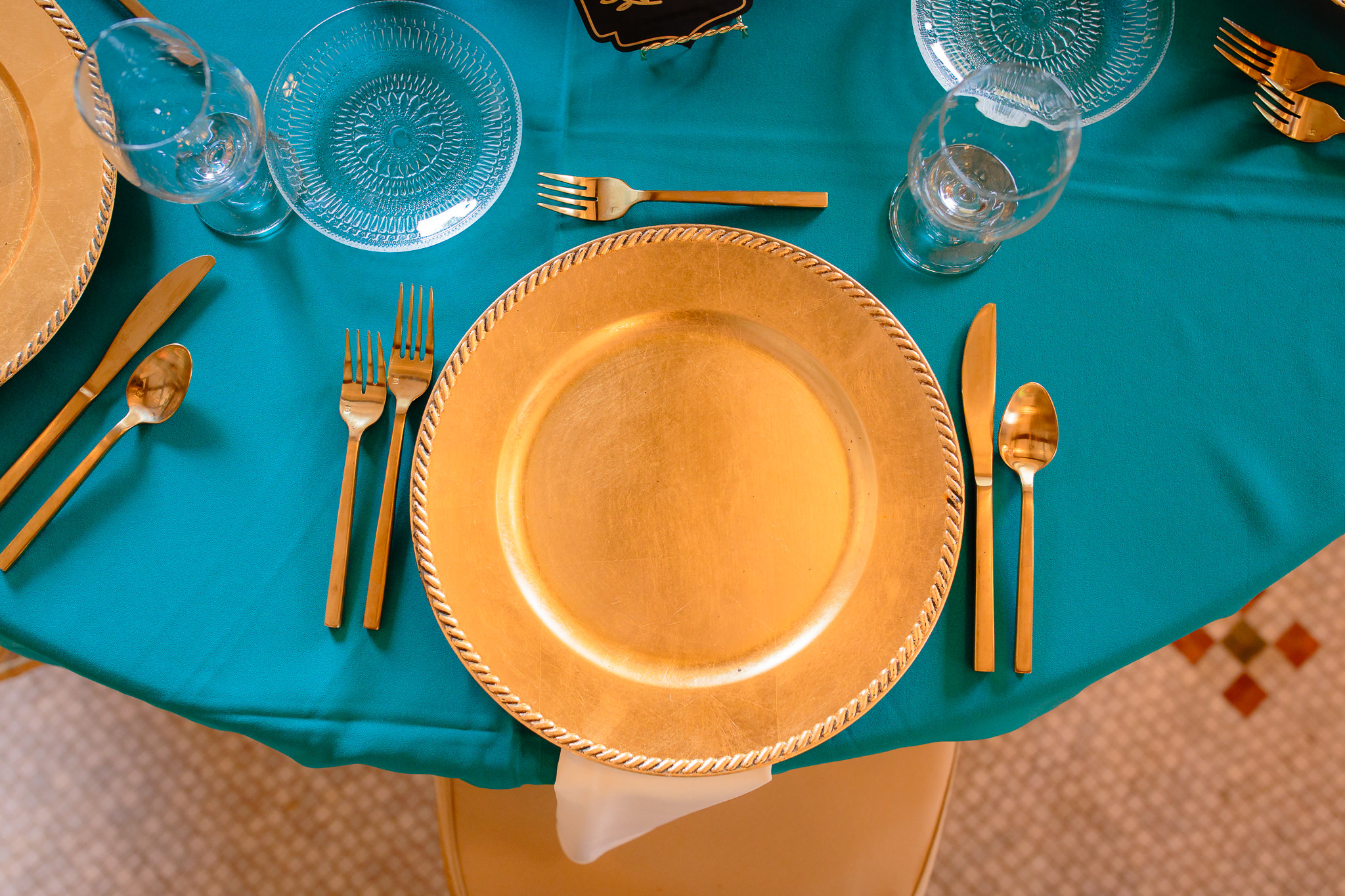 Gold charger plates and silverware on turquoise table cloth at Beaver Station