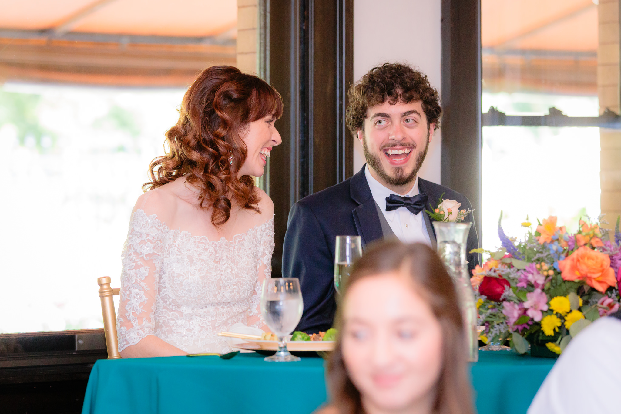 Newlyweds laugh during speeches at their Beaver Station wedding reception