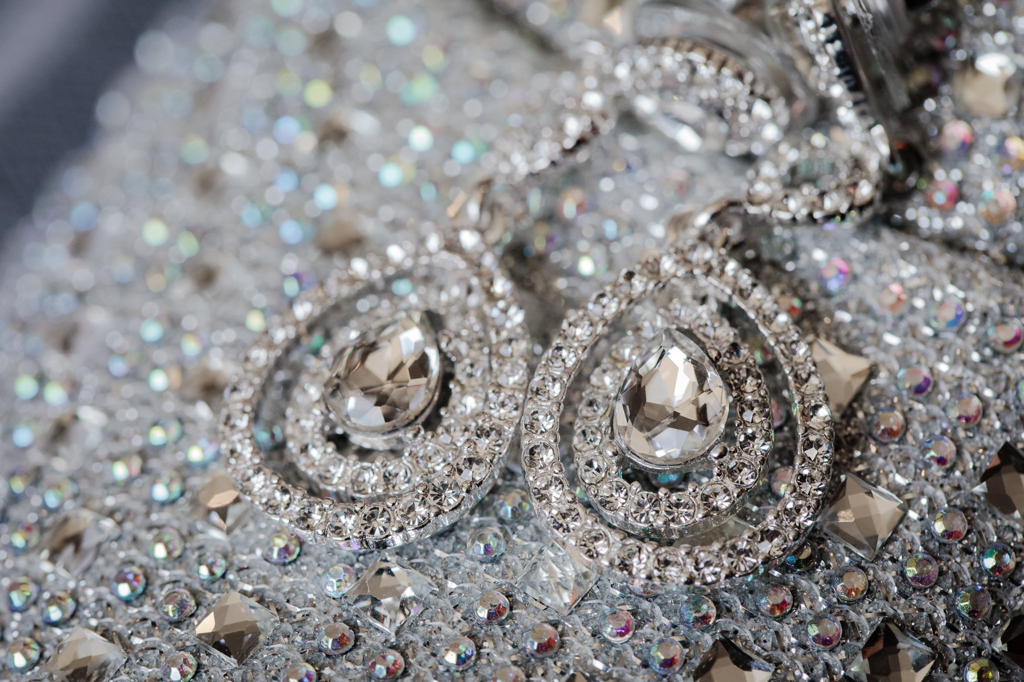 Bride's diamond teardrop earrings rest on her silver rhinestone shoes