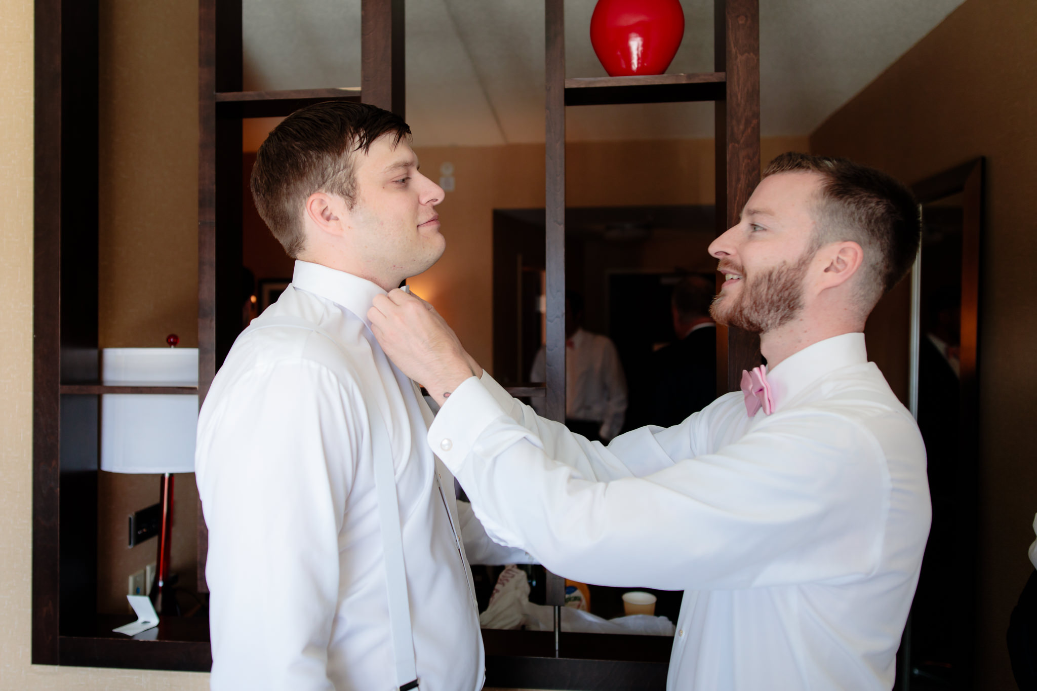 Groom's brother straightens his bowtie at Cambria Hotel in Pittsburgh, PA
