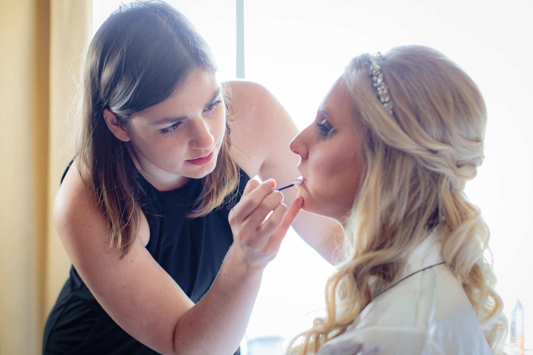 Stephanie Maust of Eye Do Makeup and Hair puts lipstick on bride at Cambria Hotel in Pittsburgh