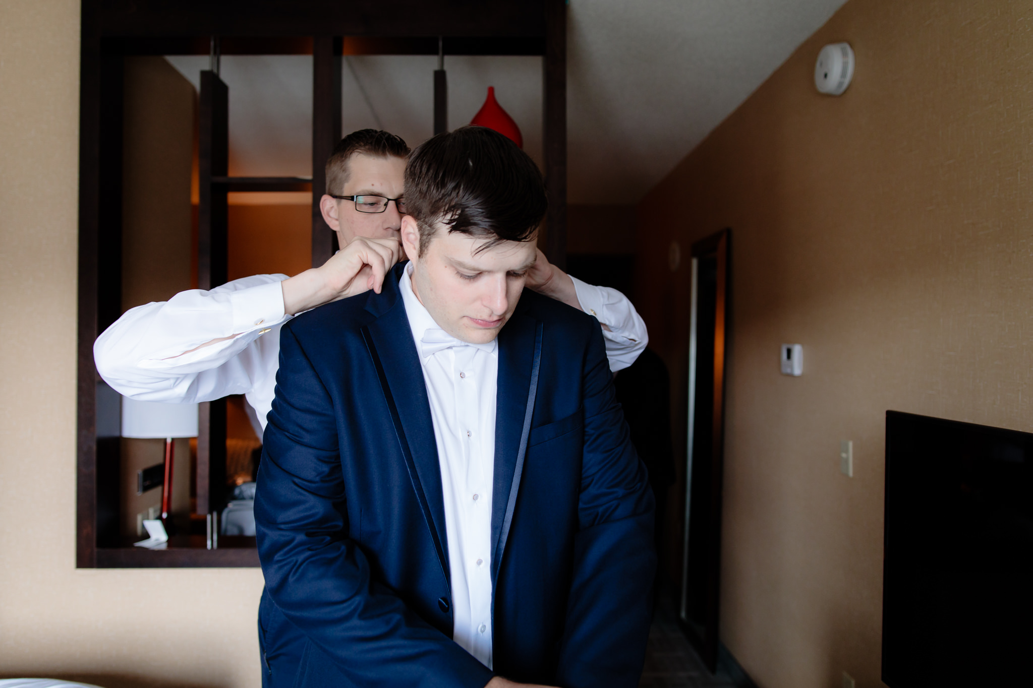 Groom's brother adjusts his collar before his wedding at Duquesne University