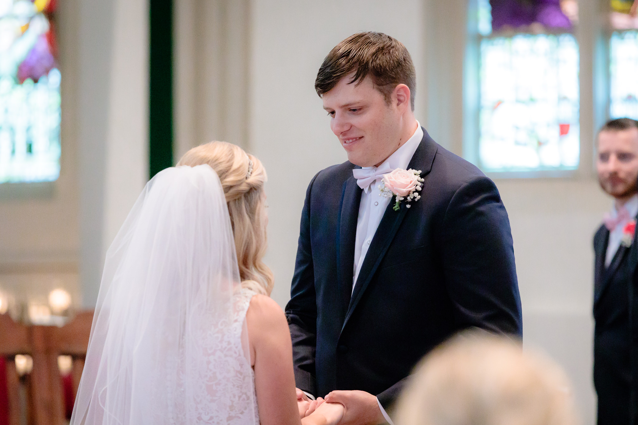 Groom smiles as bride says her vows at Duquesne University Chapel of the Holy Spirit