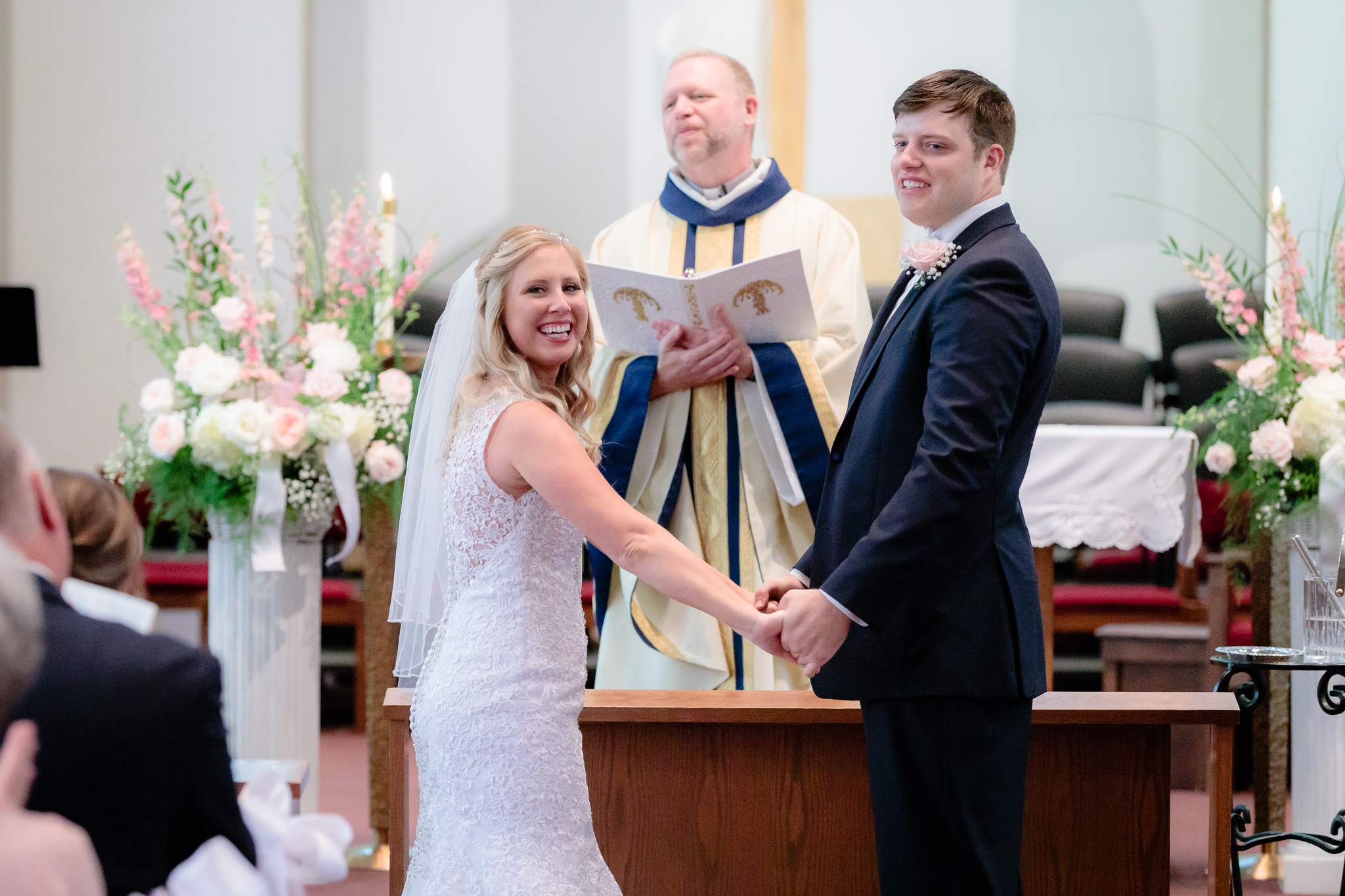 Bride & groom smile at guests during their Duquesne University wedding ceremony