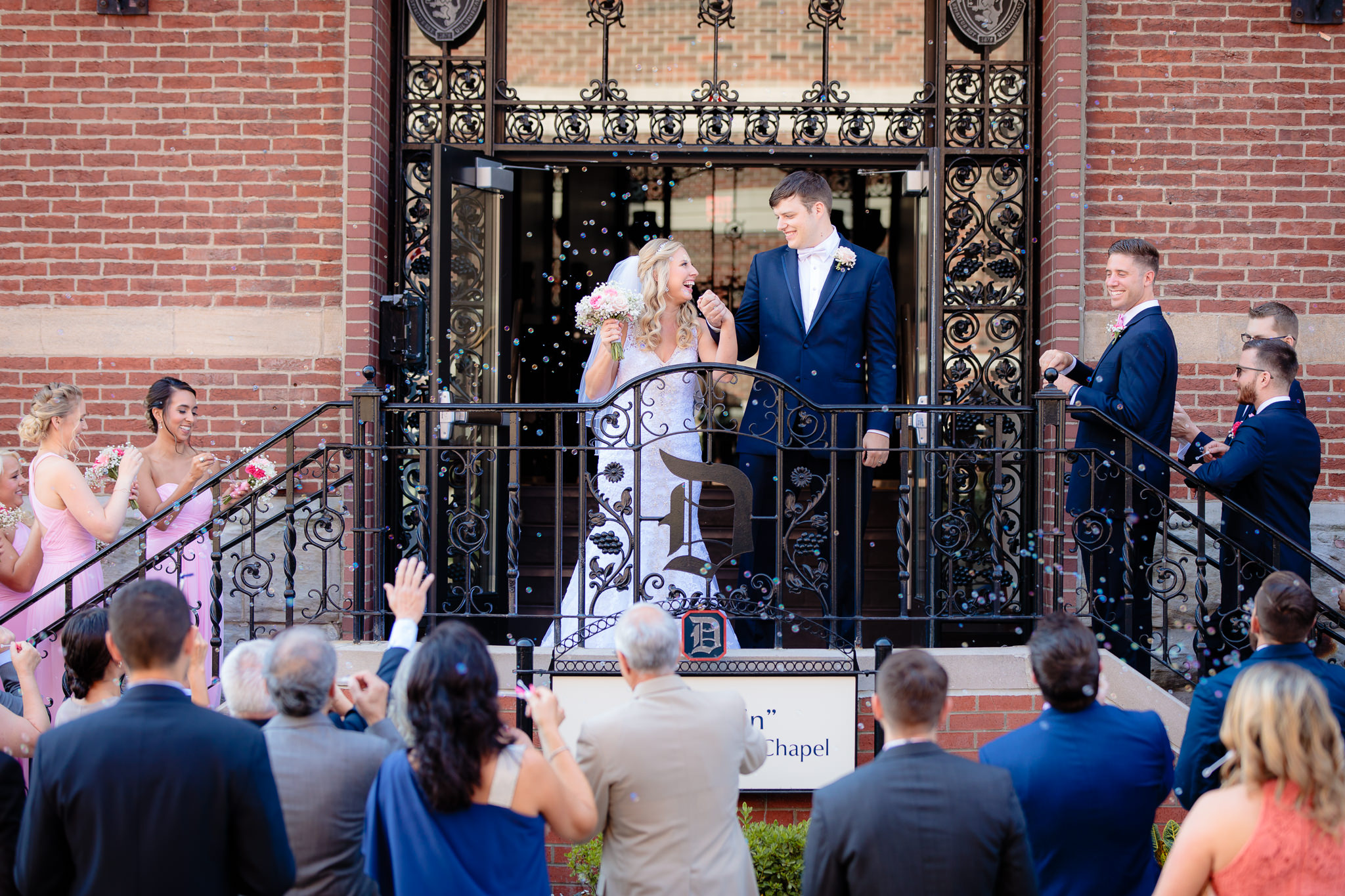 Newlyweds smile at each other during their bubble exit at Duquesne University
