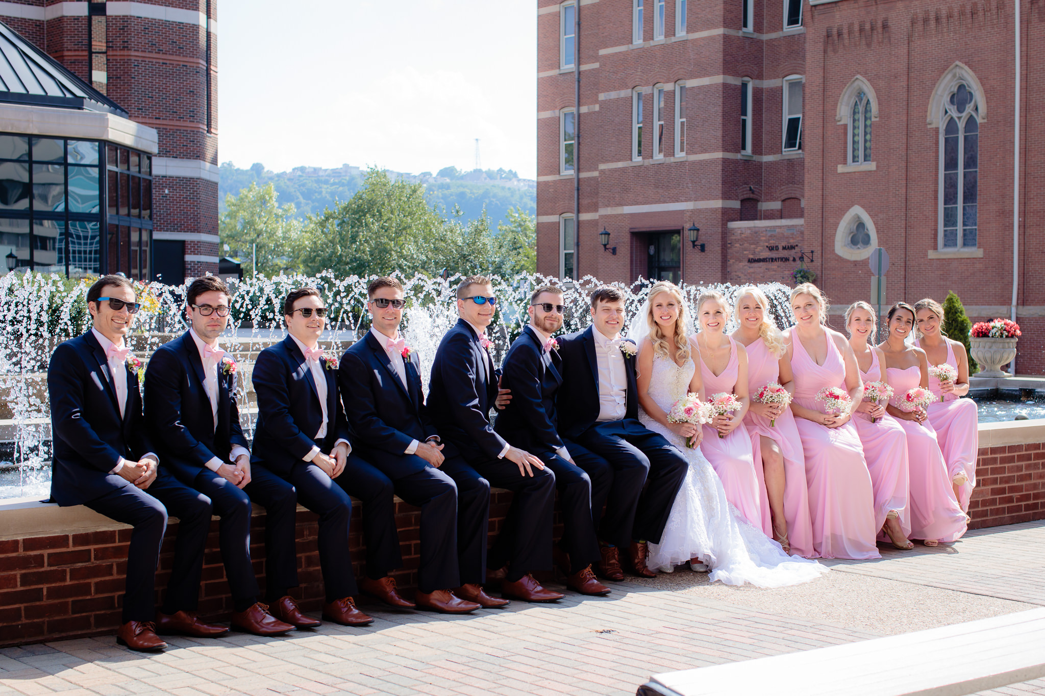 Bridal party sits on fountain wall at Duquesne University