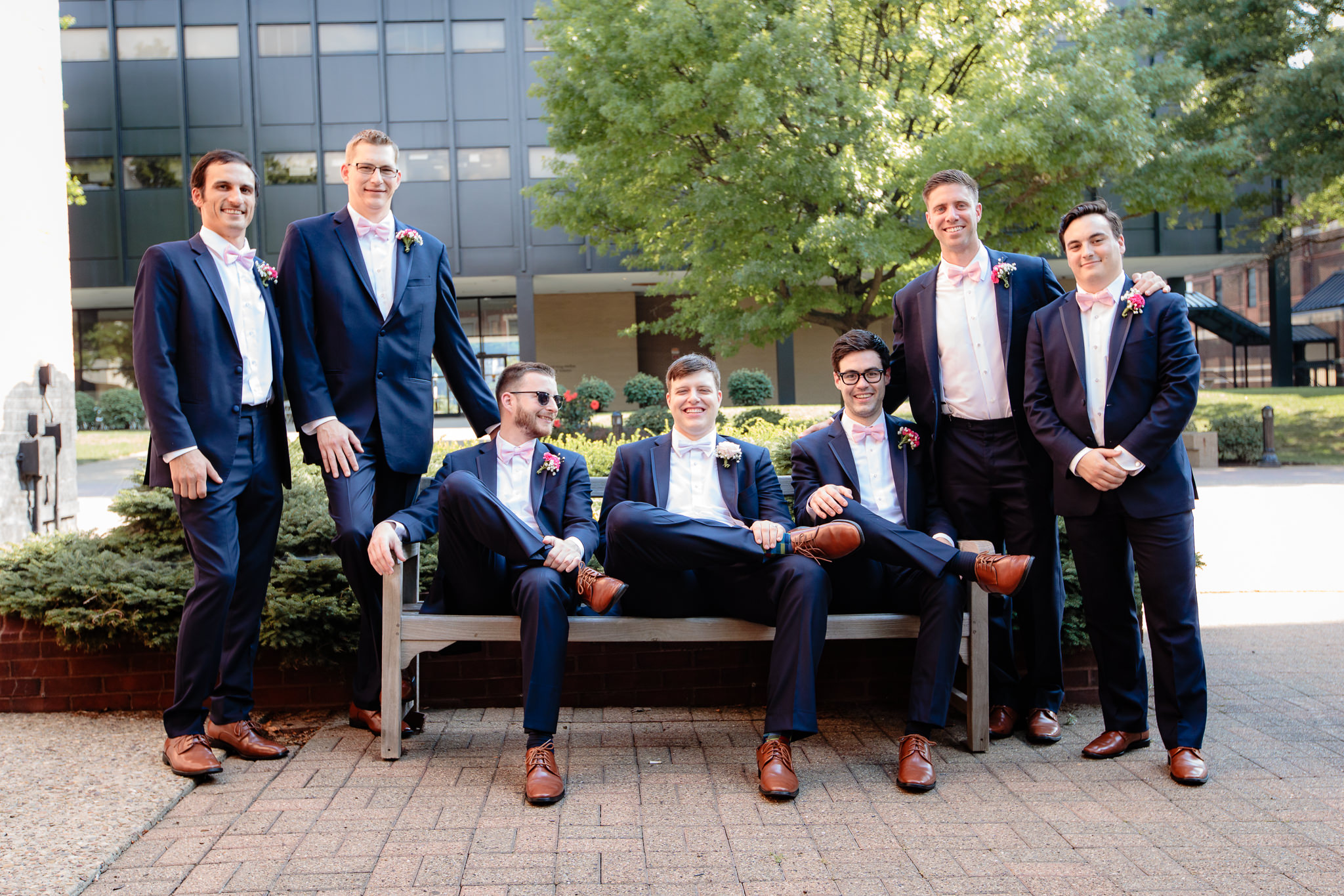 Groomsmen pose on a bench at Duquesne University