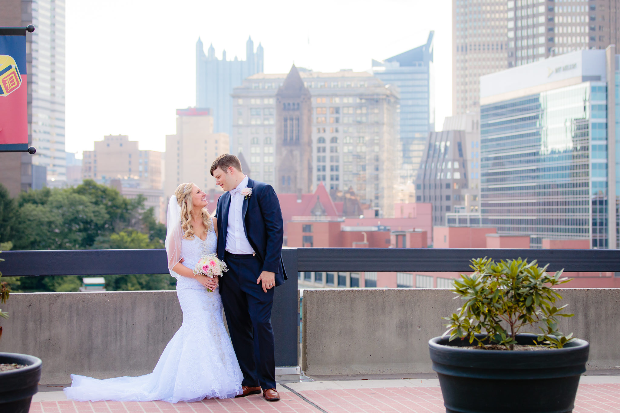 Bride & groom pose in front of downtown Pittsburgh from Duquesne University's campus
