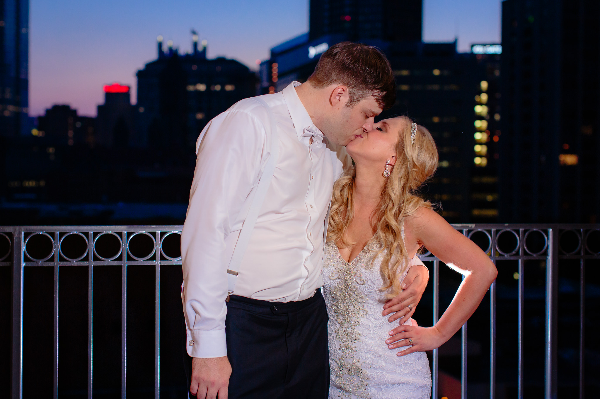 Newlyweds kiss at dusk on the patio of the Duquesne University Power Center ballroom