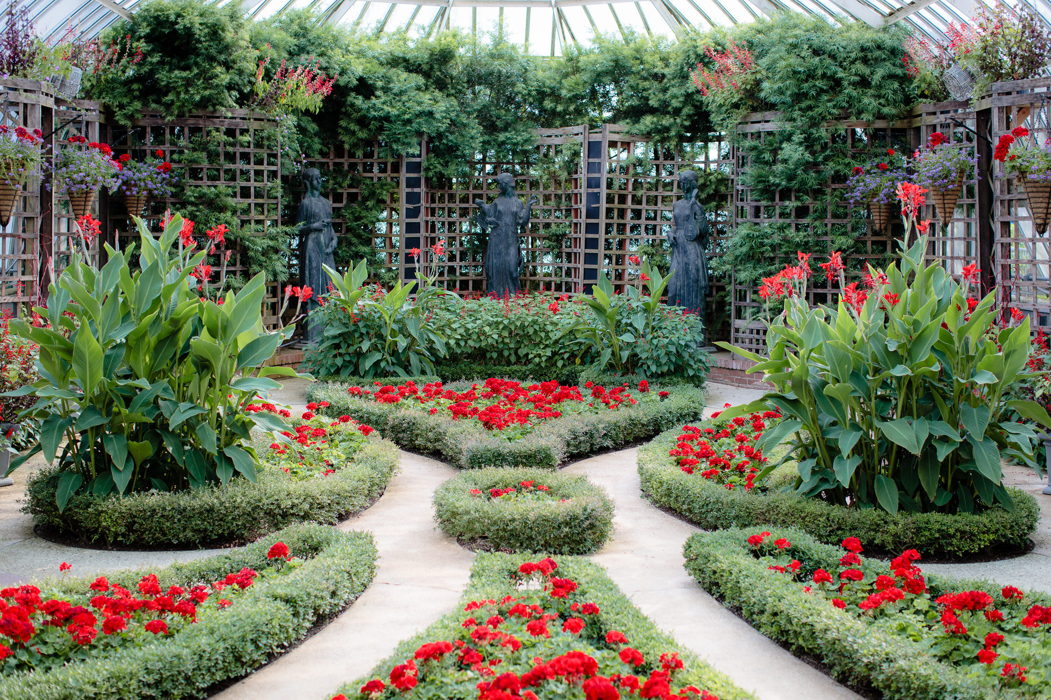 The Broderie Room inside Phipps Conservatory in Pittsburgh is full of red flowers & lush greenery