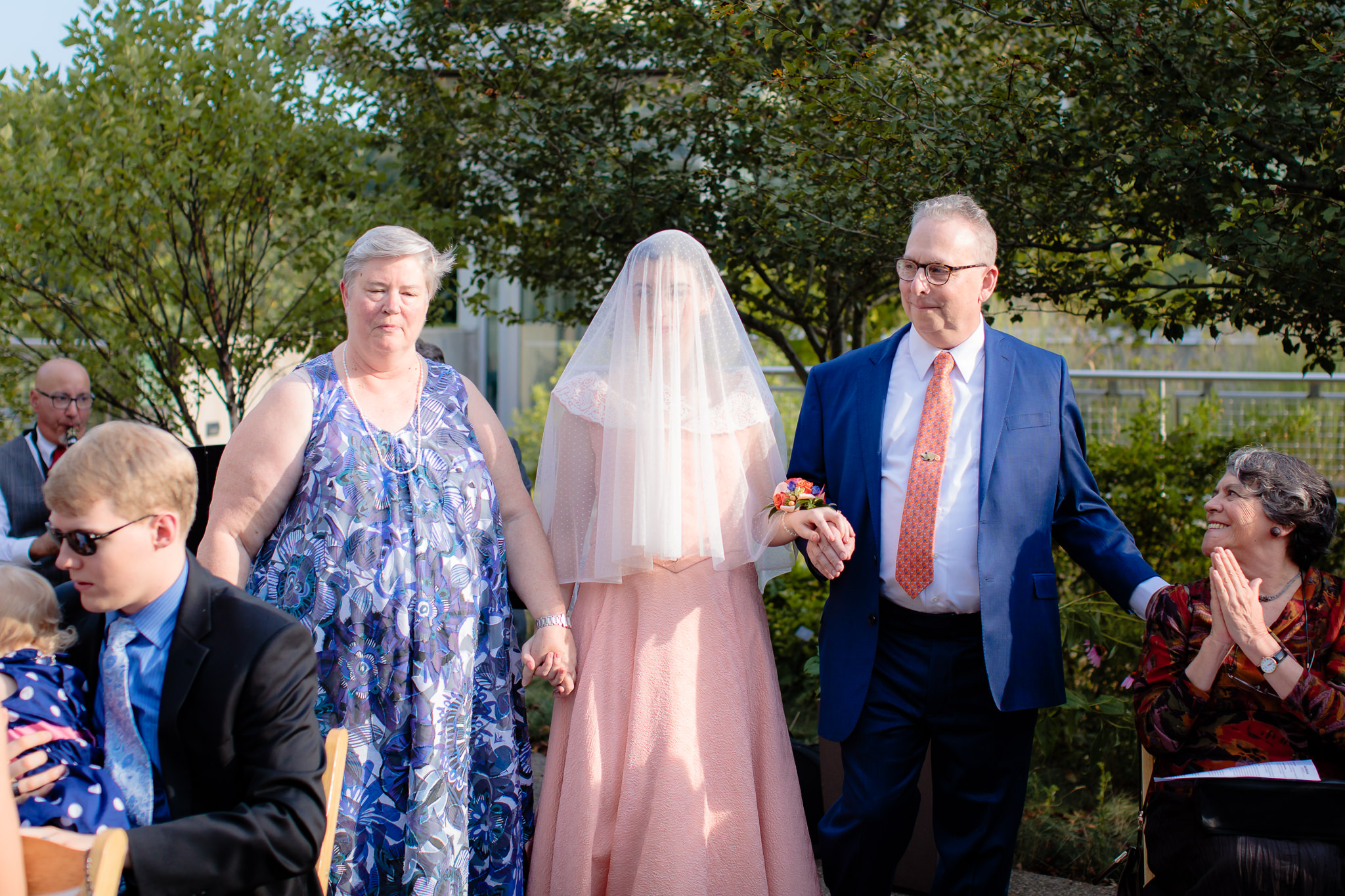 Parents of the bride walk her down the aisle at Phipps Conservatory