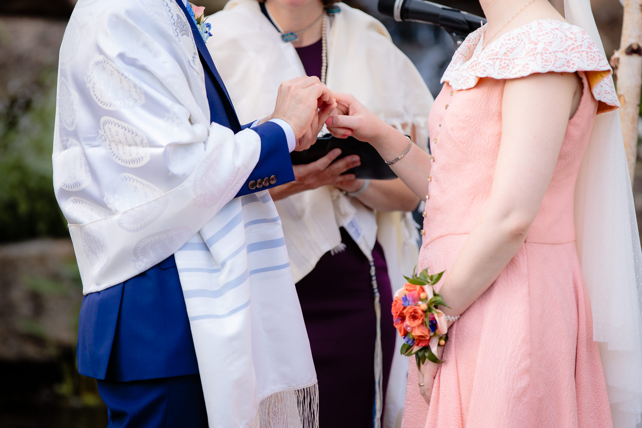 Groom places a ring on the bride's finger during a Phipps Conservatory Jewish wedding
