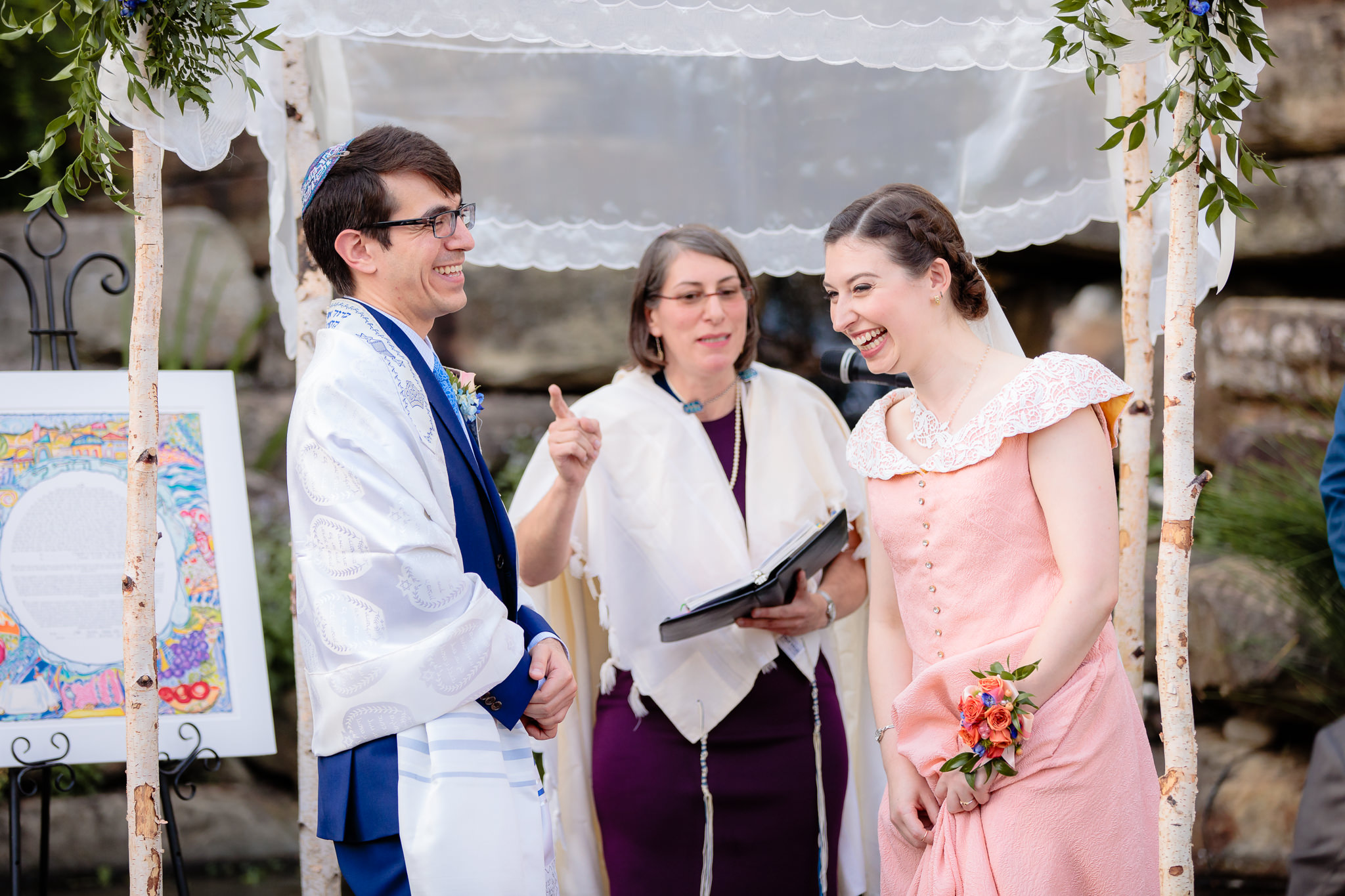 Bride & groom laugh during their Jewish wedding ceremony at Phipps Conservatory