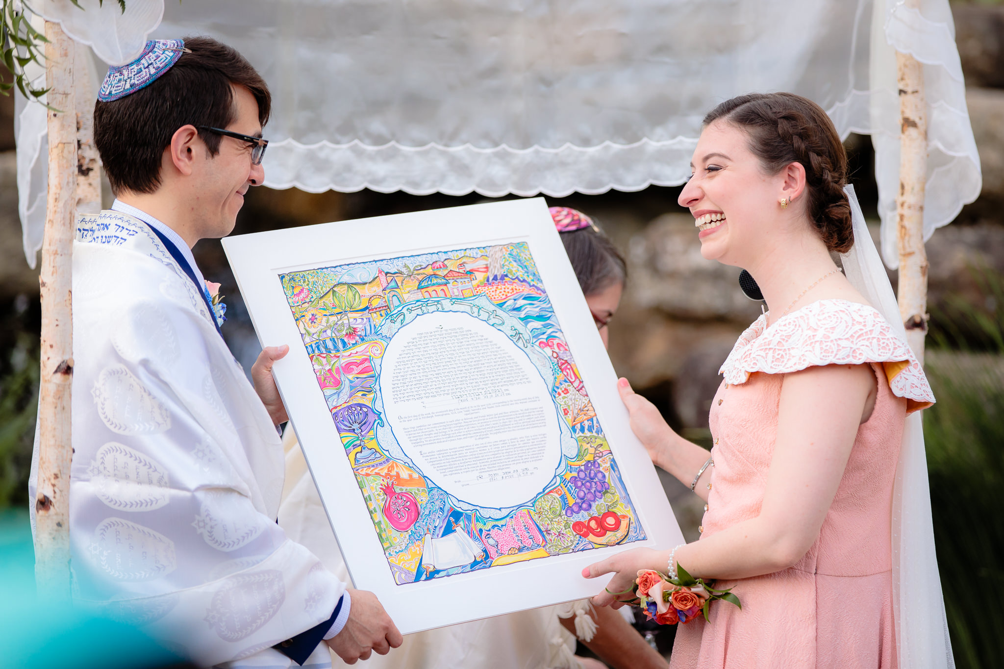 Bride & groom laugh as they read the Ketubah contract aloud during their Jewish wedding ceremony at Phipps Conservatory
