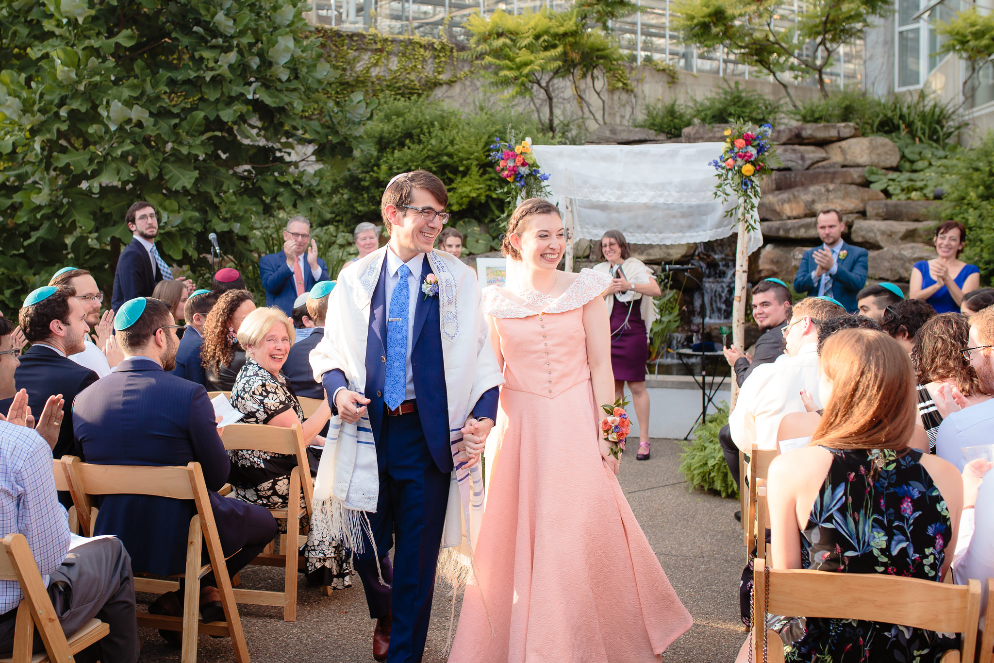 Newlyweds exit their outdoor Jewish wedding ceremony at Phipps Conservatory