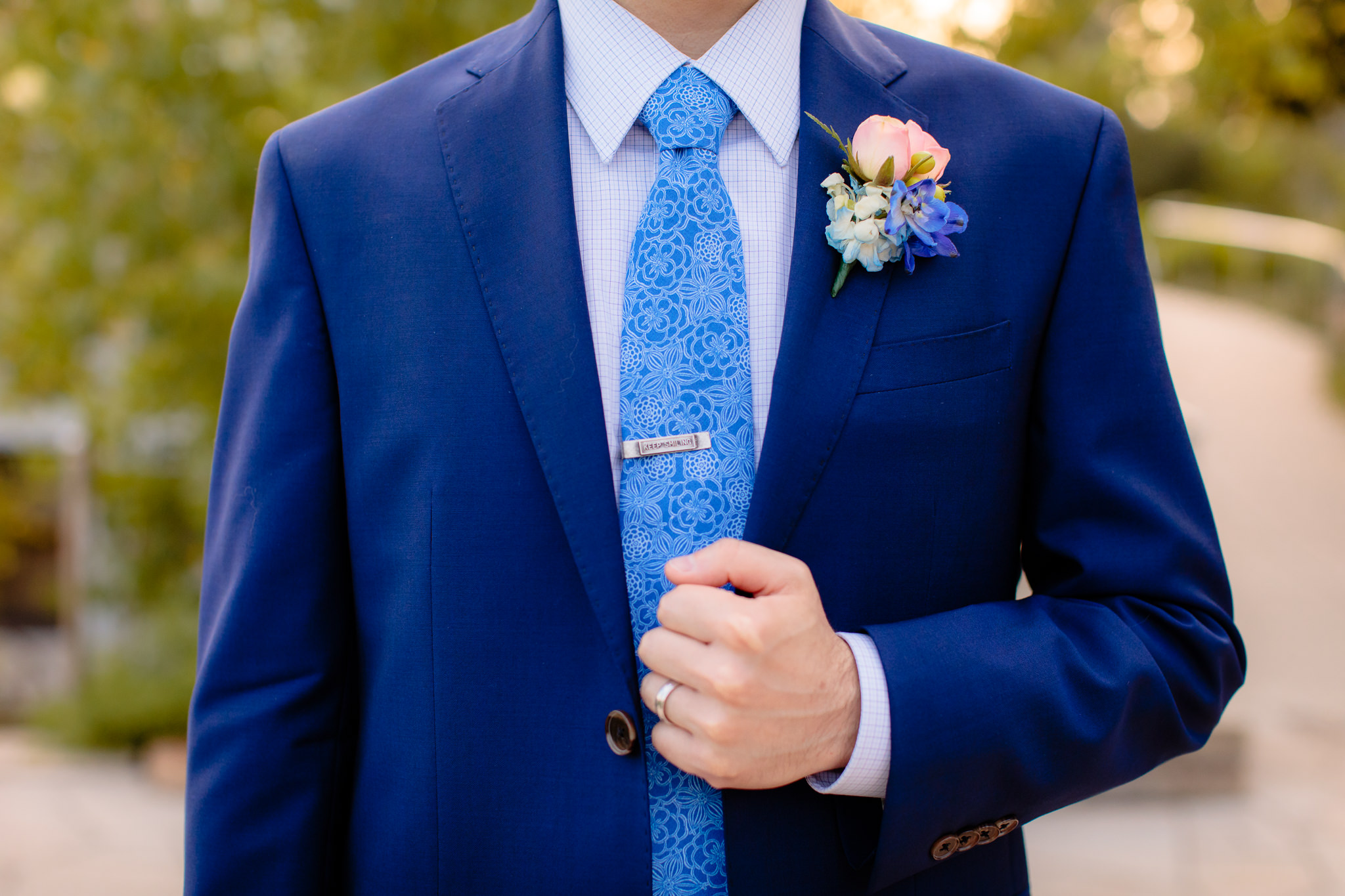 Groom's custom blue suit by Joseph Orlando Clothiers and a floral boutonniere by Hepatica