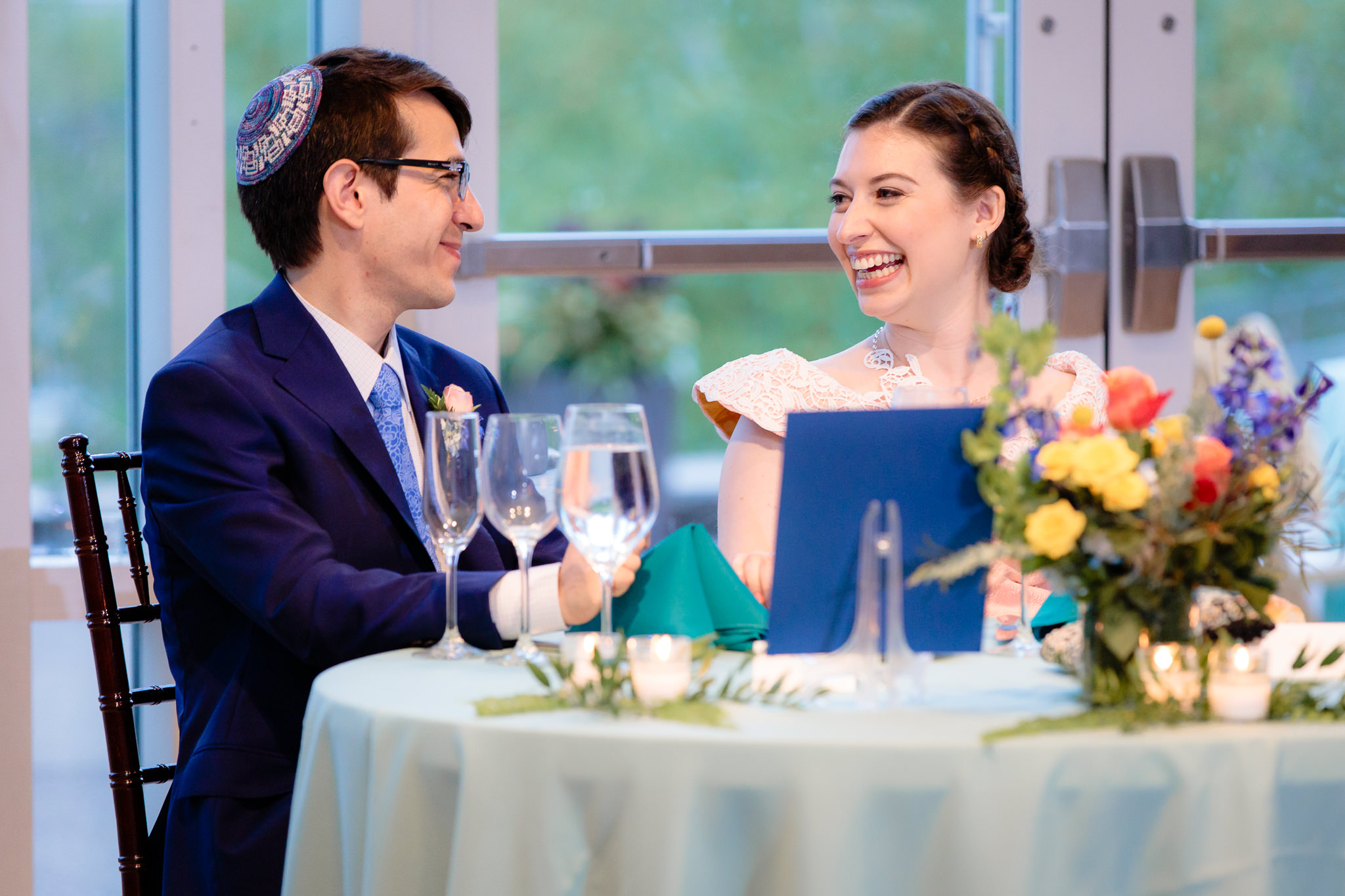 Newlyweds laugh during speeches at their Phipps Conservatory wedding reception