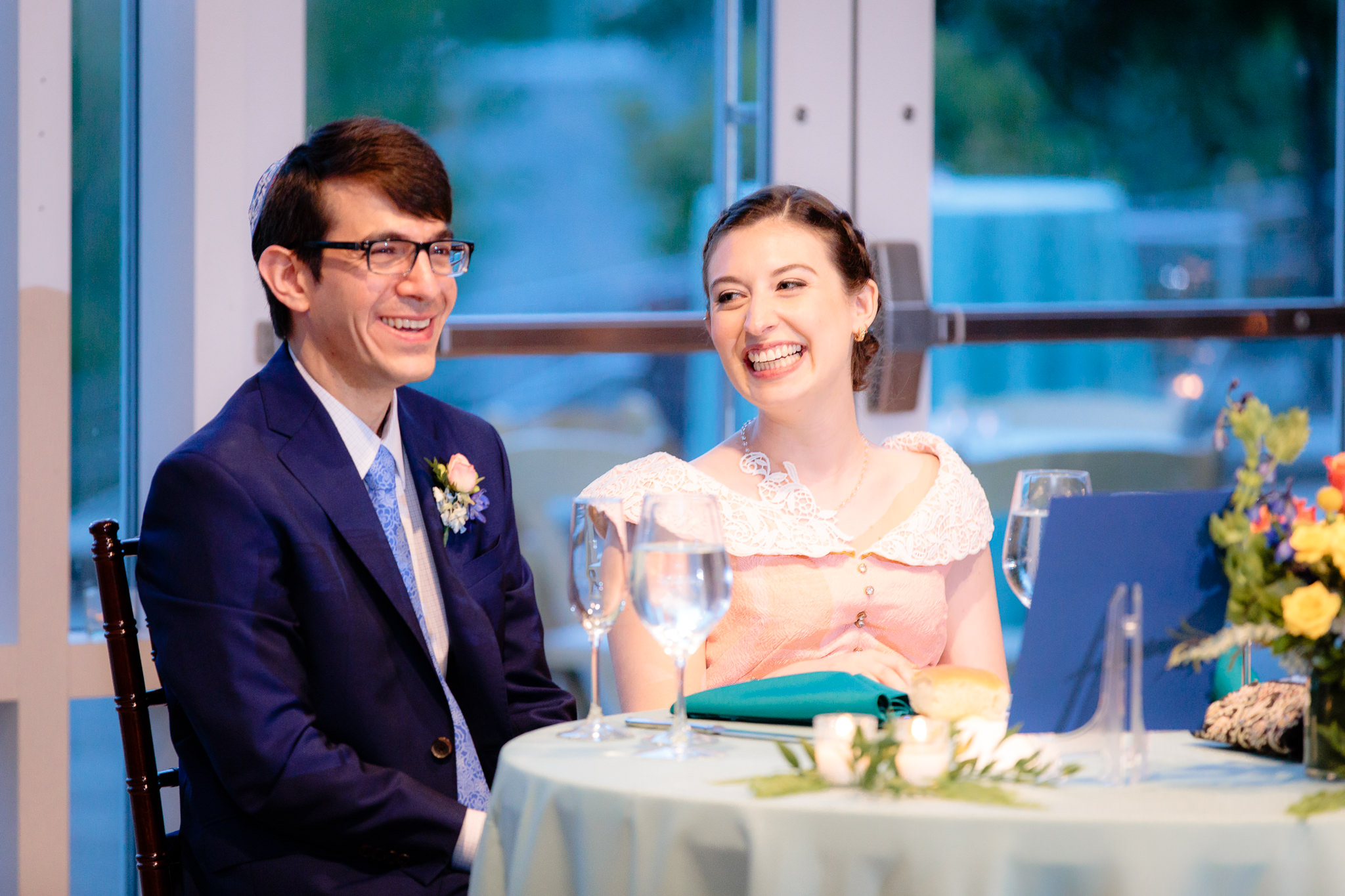 Bride & groom laugh at the sweetheart table at Phipps Conservatory