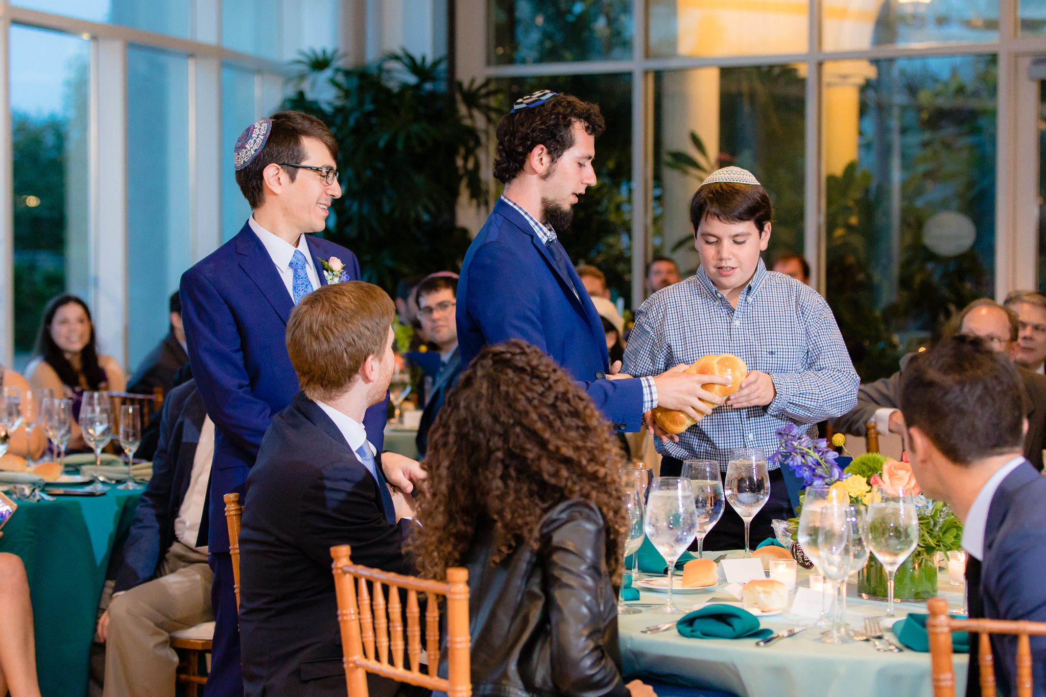 Brothers of the groom bless the Challah at a Jewish wedding reception at Phipps Conservatory