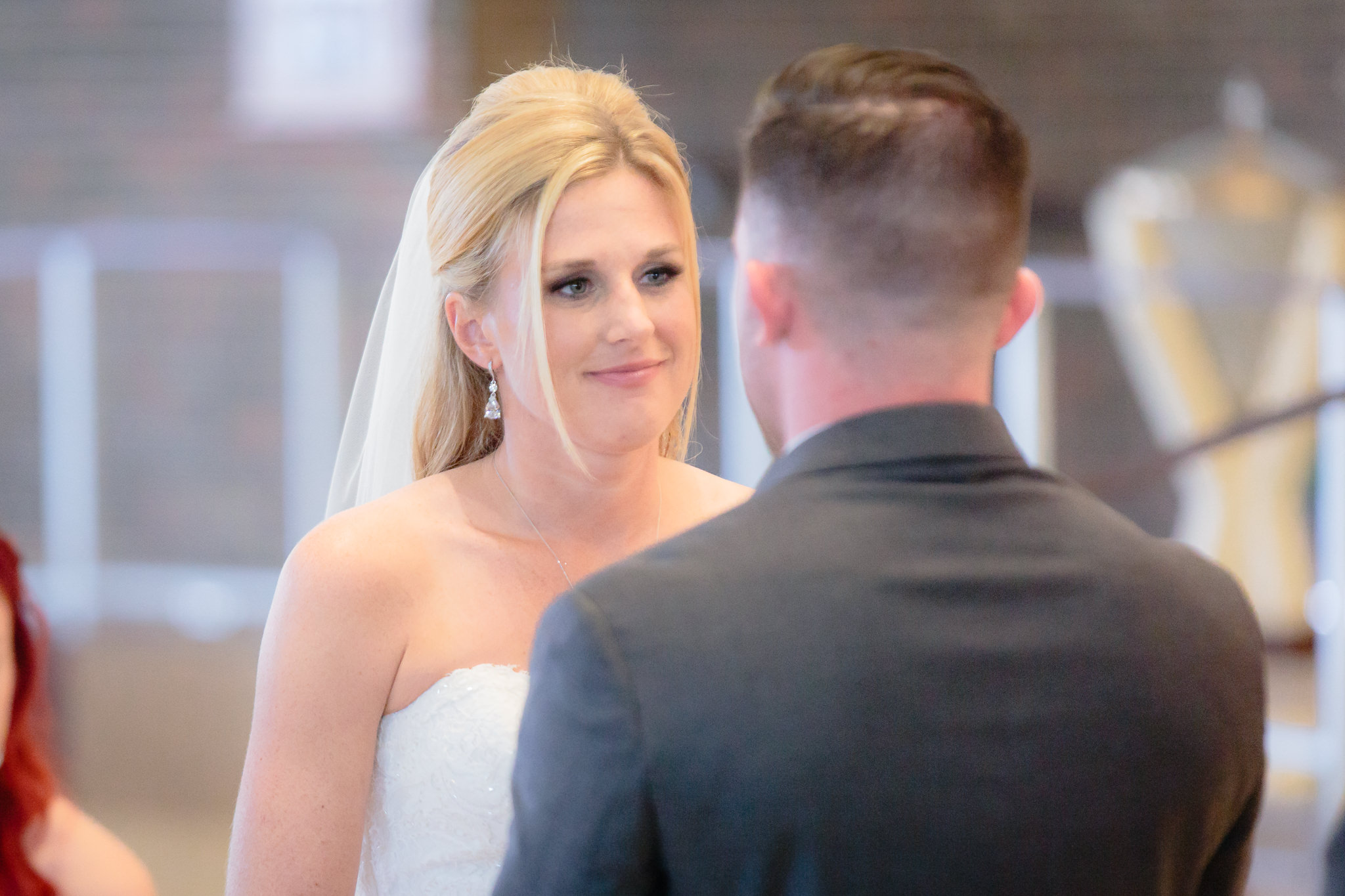 Bride smiles at the groom during vows at a Holy Trinity Catholic Church wedding