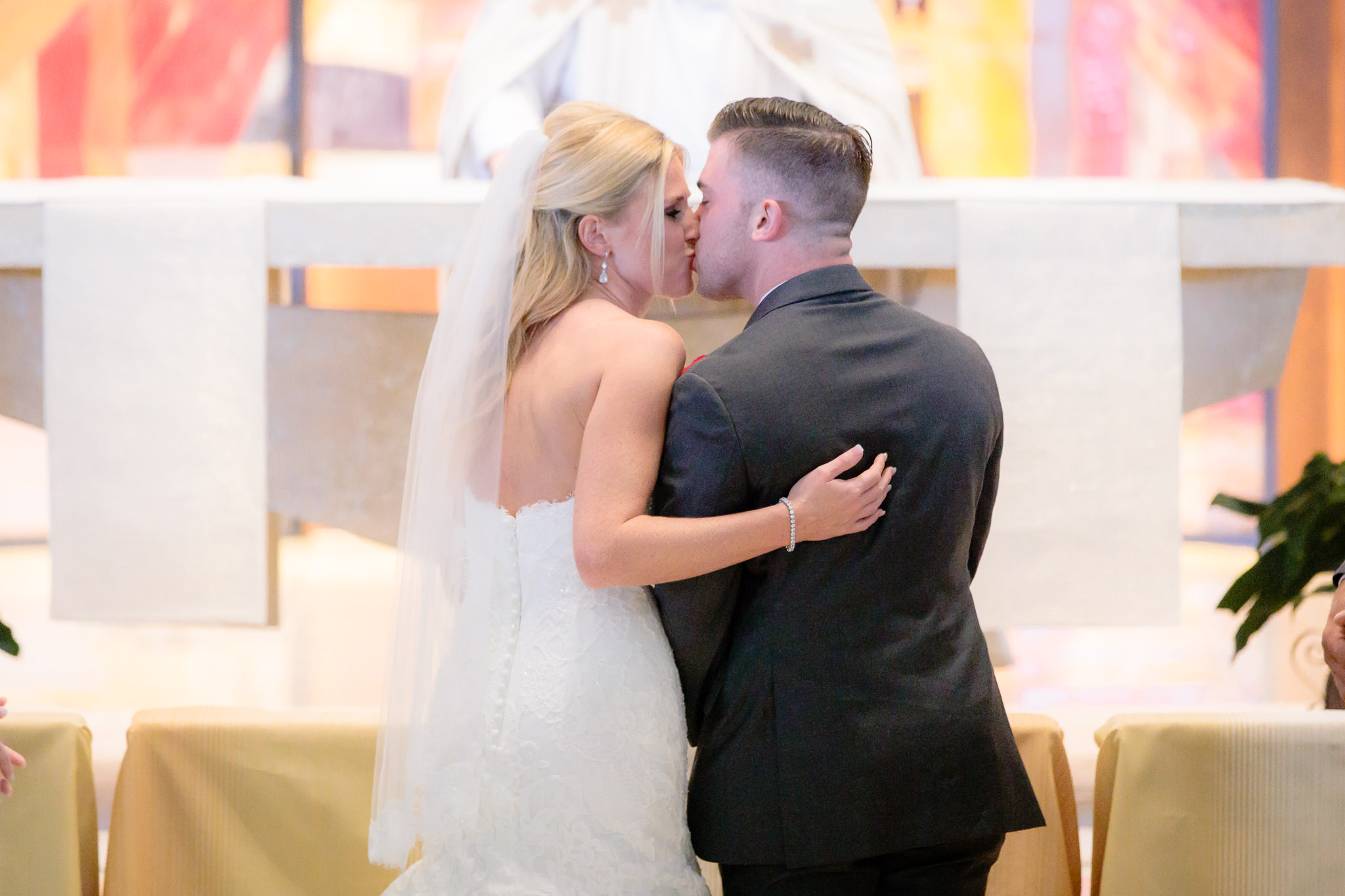 Newlyweds kiss during their Holy Trinity Catholic Church wedding ceremony