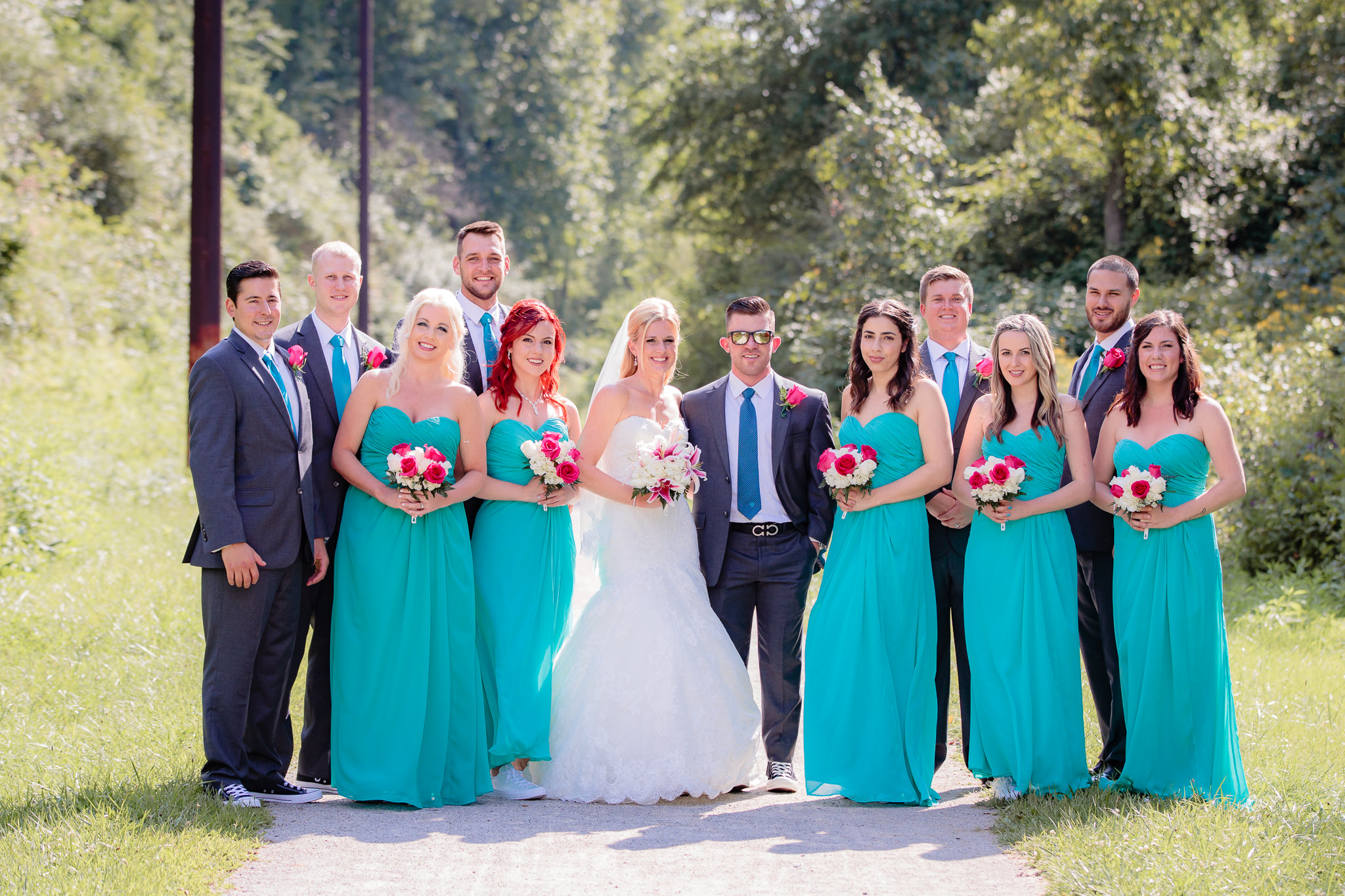 Bridal party in grey suits and turquoise dresses on a bike trail