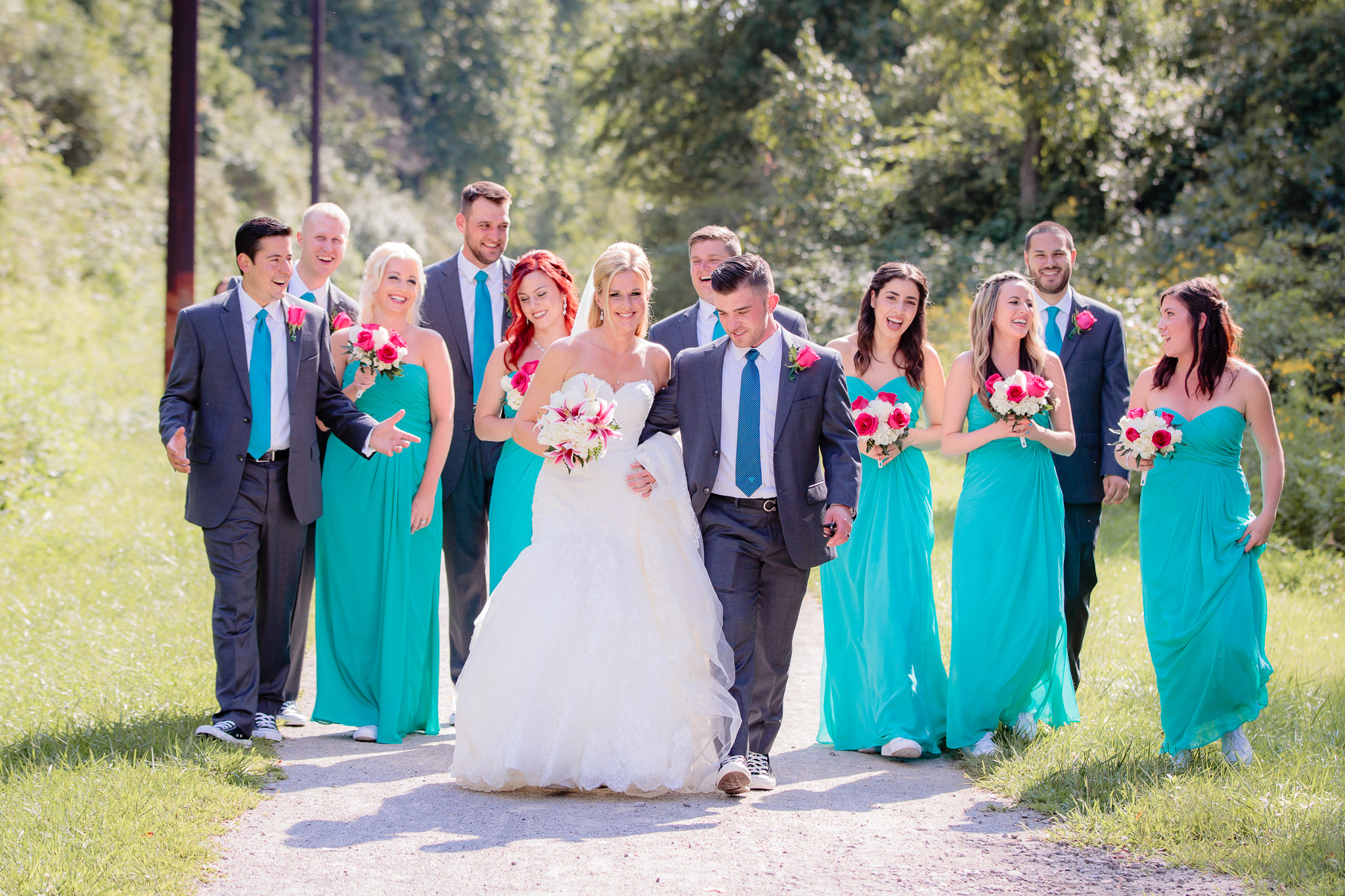Bridal party walking on a gravel pathway after a Holy Trinity Catholic Church wedding
