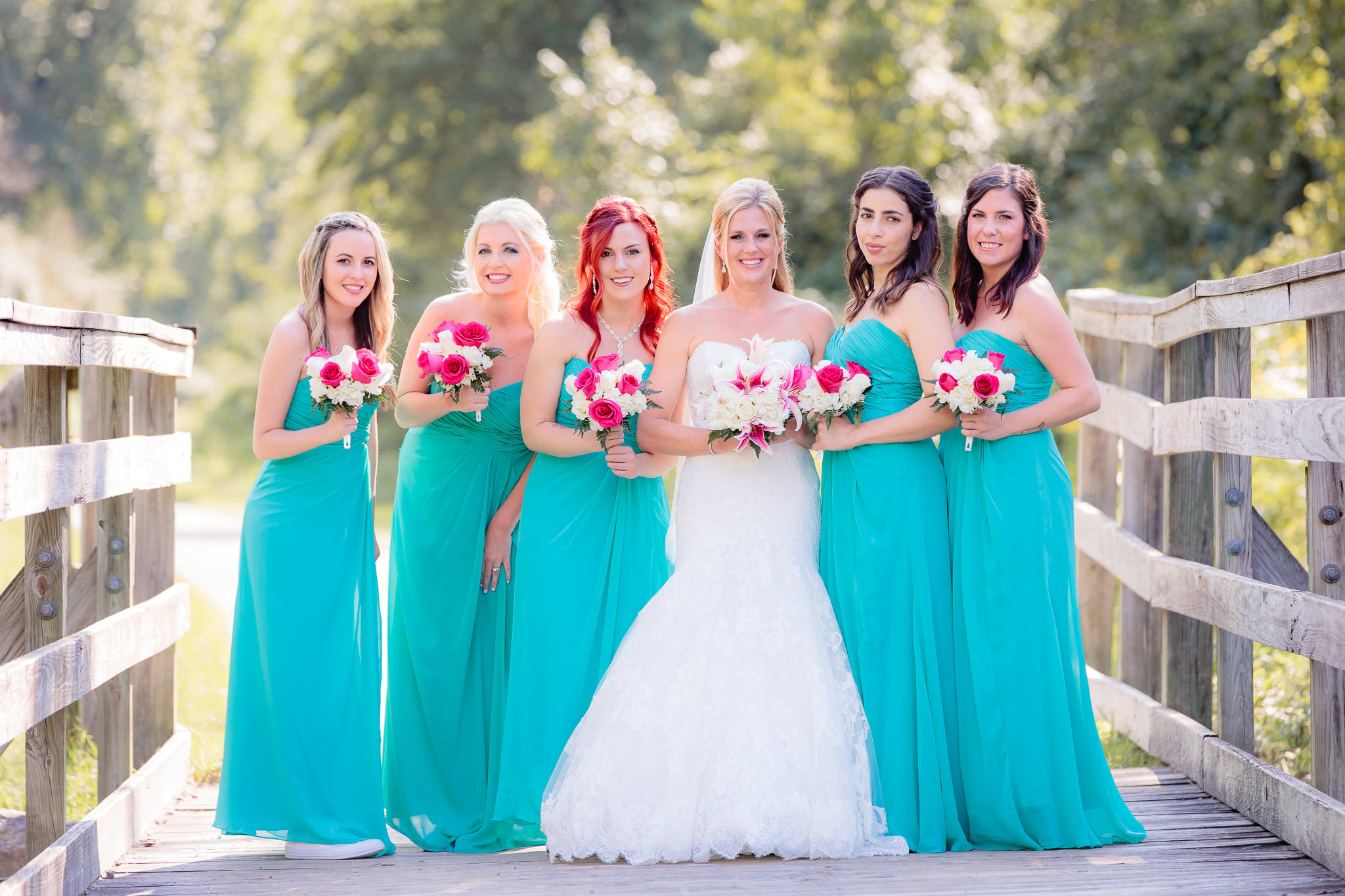 Bridesmaids in turquoise dresses and pink and white bouquets