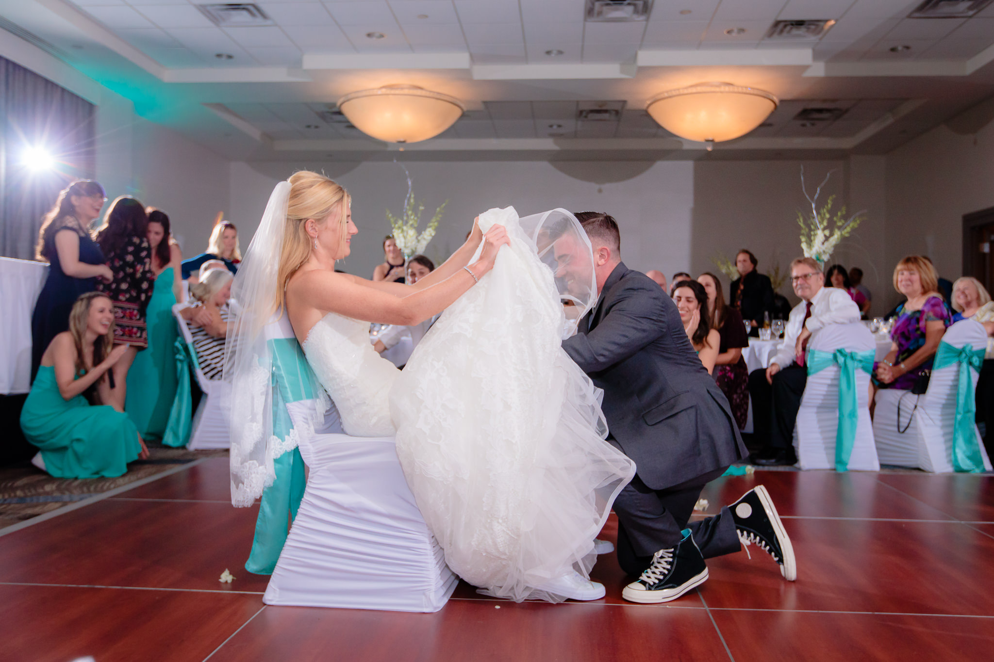 Groom removes the bride's garter at the Pittsburgh Airport Marriott
